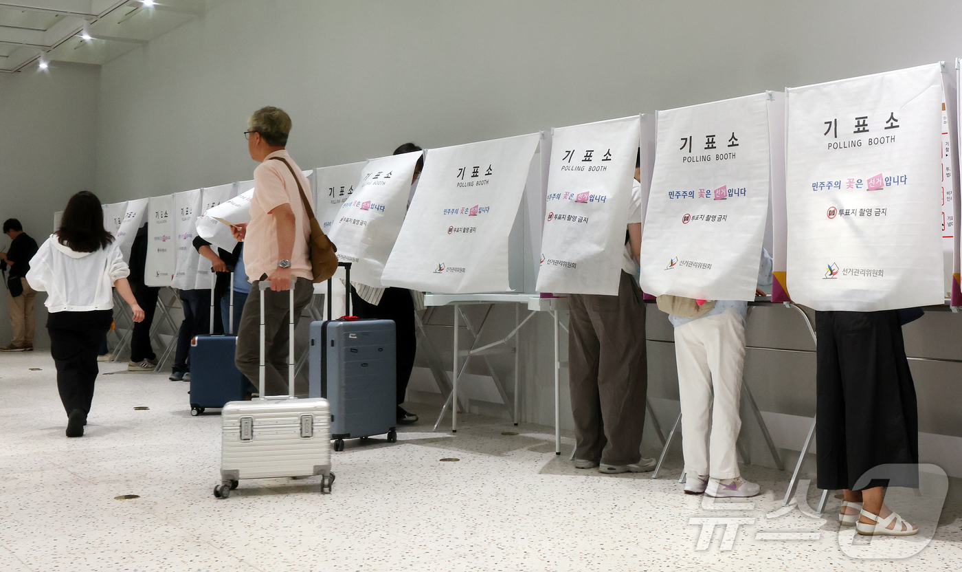 (인천공항=뉴스1) 김진환 기자 = 6·3지방선거 사전투표가 시작된 29일 오전 인천국제공항 제1터미널 출국장에 설치된 사전투표소에서 시민들이 출국 전 사전투표를 하고 있다. 20 …