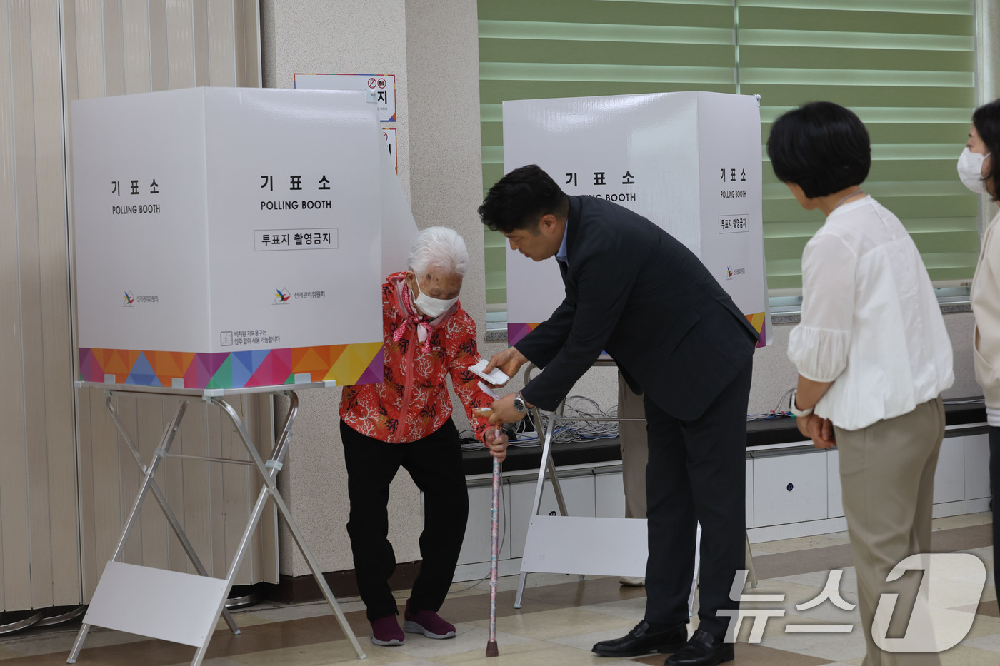 (광주=뉴스1) 박지현 기자 = 전국동시지방선거 사전투표 첫날인 29일 광주 북구 일곡동 사전투표소에서 104세 어르신이 사전투표를 마치고 손주의 도움을 받아 투표함으로 향하고 있 …