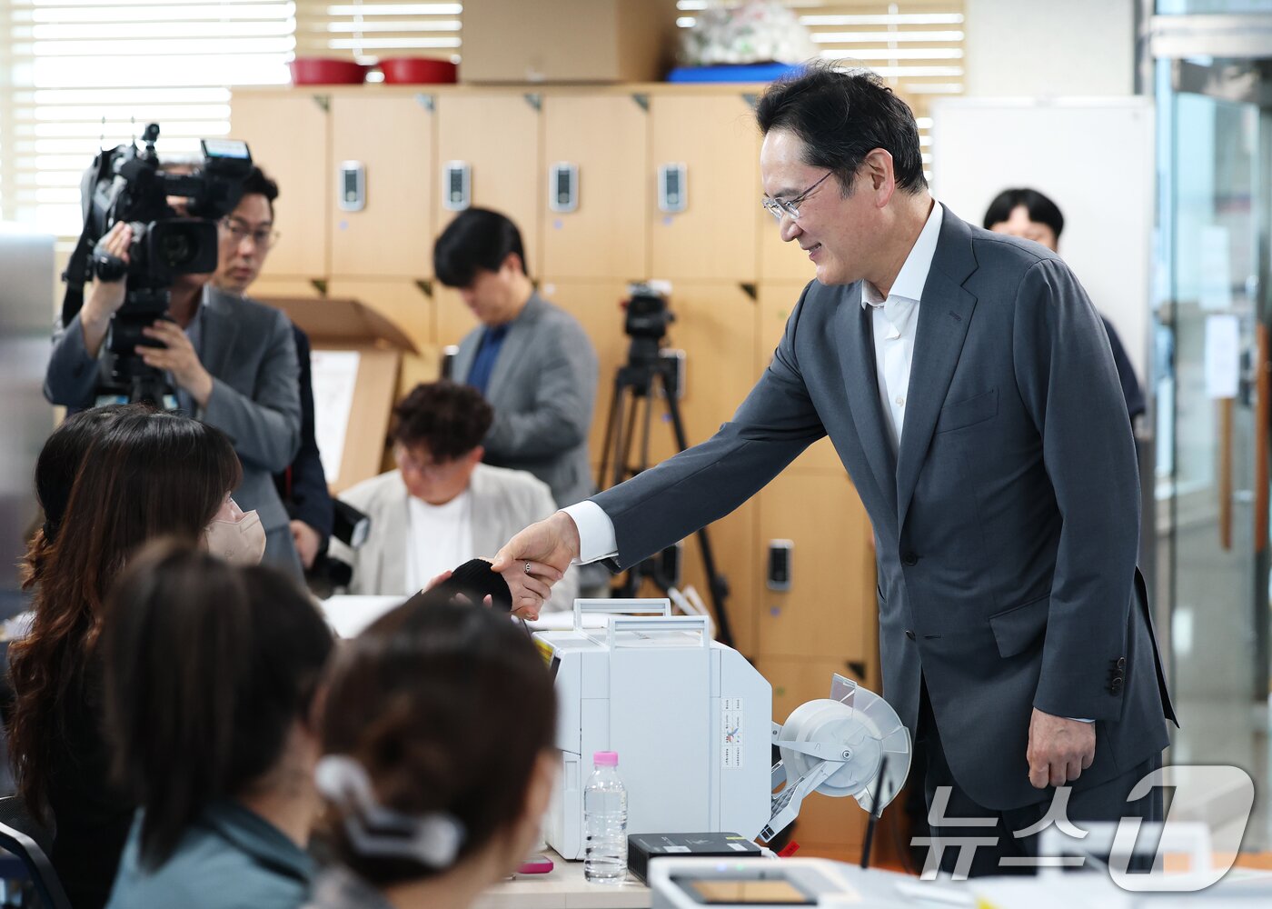 본문 이미지 - 이재용 삼성전자 회장이 제9회 전국동시지방선거 사전투표 첫날인 29일 오전 서울 용산구 한남동주민센터에 마련된 사전투표소를 찾아 투표 사무원들과 악수를 나누고 있다. 2026.5.29 ⓒ 뉴스1 오대일 기자