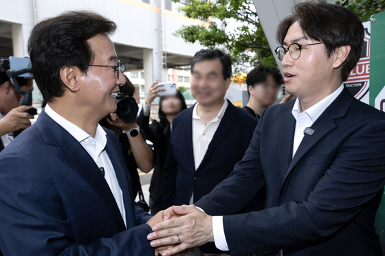 사전투표소에서 만나 악수하는 전재수·하정우