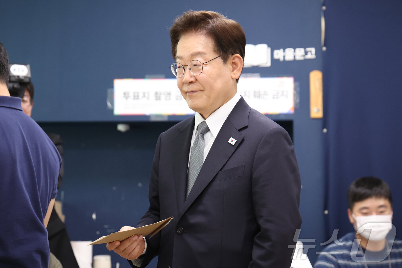본문 이미지 - 이재명 대통령이 제9회 전국동시지방선거 사전투표 첫날인 29일 서울 삼청동 주민센터에 마련된 사전투표소에서 투표를 하기 위해 투표 용지를 들고 기다리고 있다. 2026.5.29 ⓒ 뉴스1 허경 기자