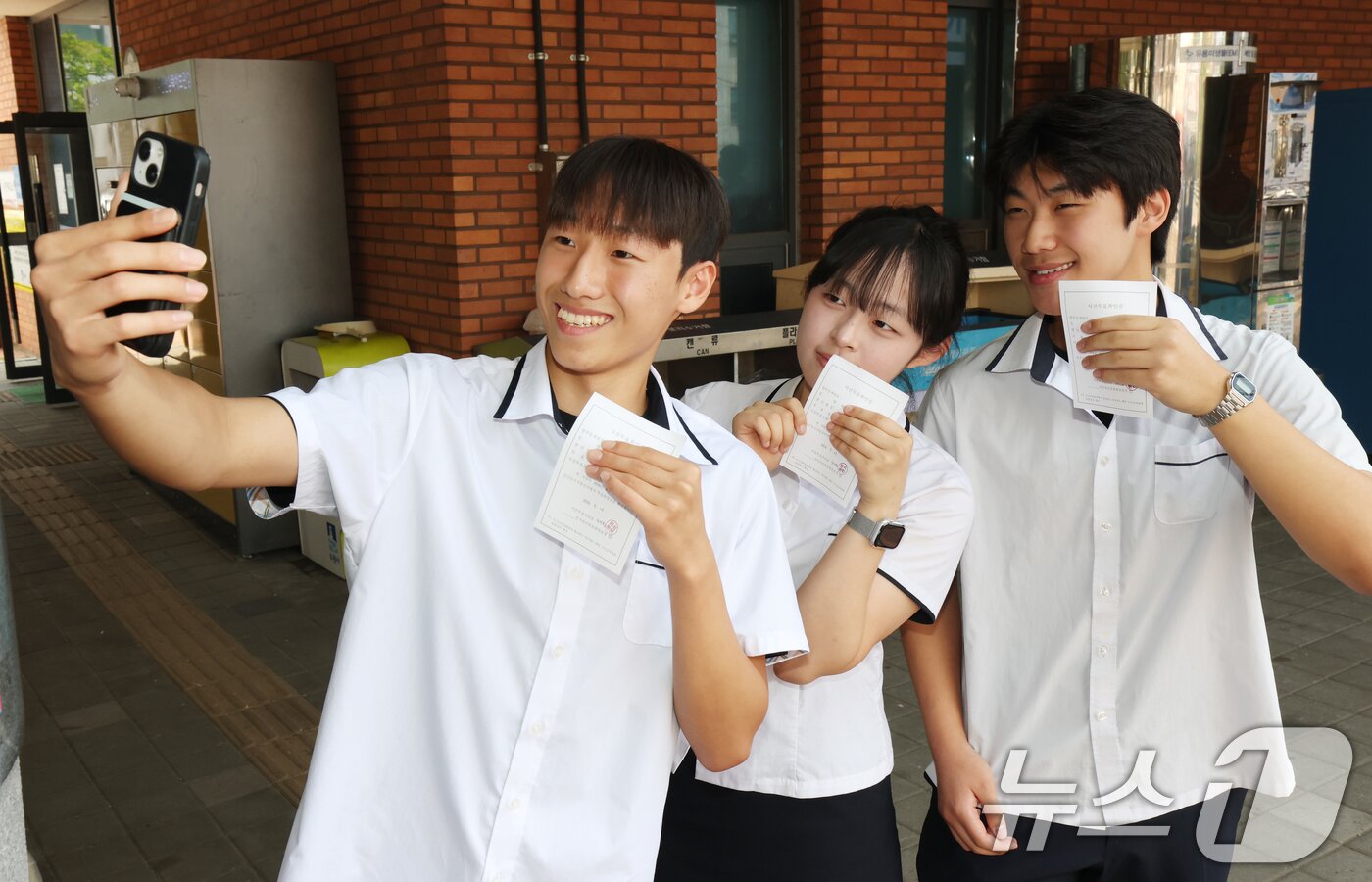 본문 이미지 - 6·3지방선거와 국회의원 재·보궐선거 사전투표 첫날인 29일 경기 수원시 장안구 연무동 행정복지센터에 마련된 사전투표소에서 사전투표를 마친 삼일공업고등학교 3학년 학생들이 투표확인증을 들고 인증샷을 남기고 있다. 2026.5.29 ⓒ 뉴스1 김영운 기자