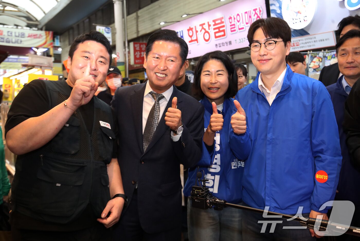 본문 이미지 - 정청래 더불어민주당 대표와 부산 북갑 국회의원 보궐선거에 출마하는 하정우 전 청와대 AI미래기획수석이 3일 부산 북구 구포시장을 찾아 상인들과 인사를 나눈 뒤 엄지를 들어 보이고 있다. 2026.5.3 ⓒ 뉴스1 윤일지 기자