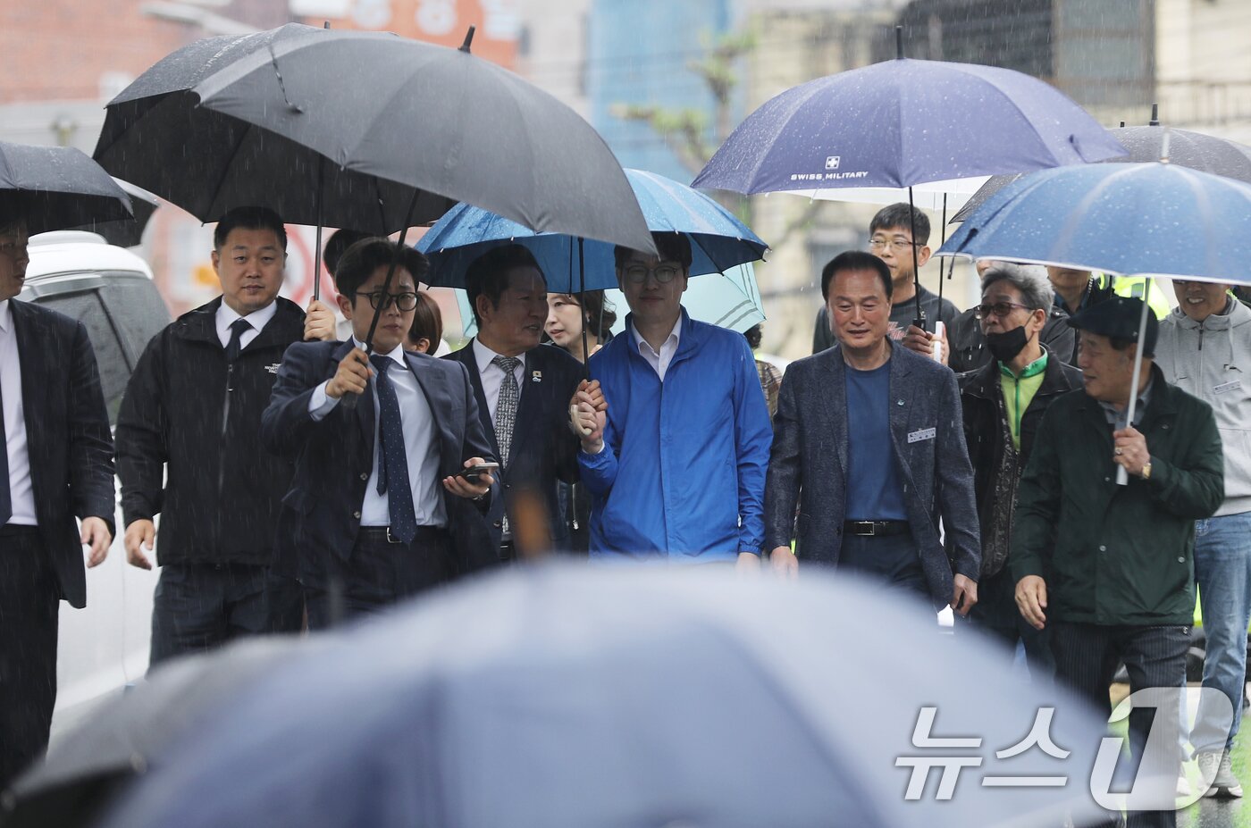 본문 이미지 - 정청래 더불어민주당 대표와 부산 북갑 국회의원 보궐선거에 출마하는 하정우 전 청와대 AI미래기획수석이 3일 함께 우산을 쓰고 부산 북구 구포시장으로 이동하고 있다. 2026.5.3 ⓒ 뉴스1 윤일지 기자