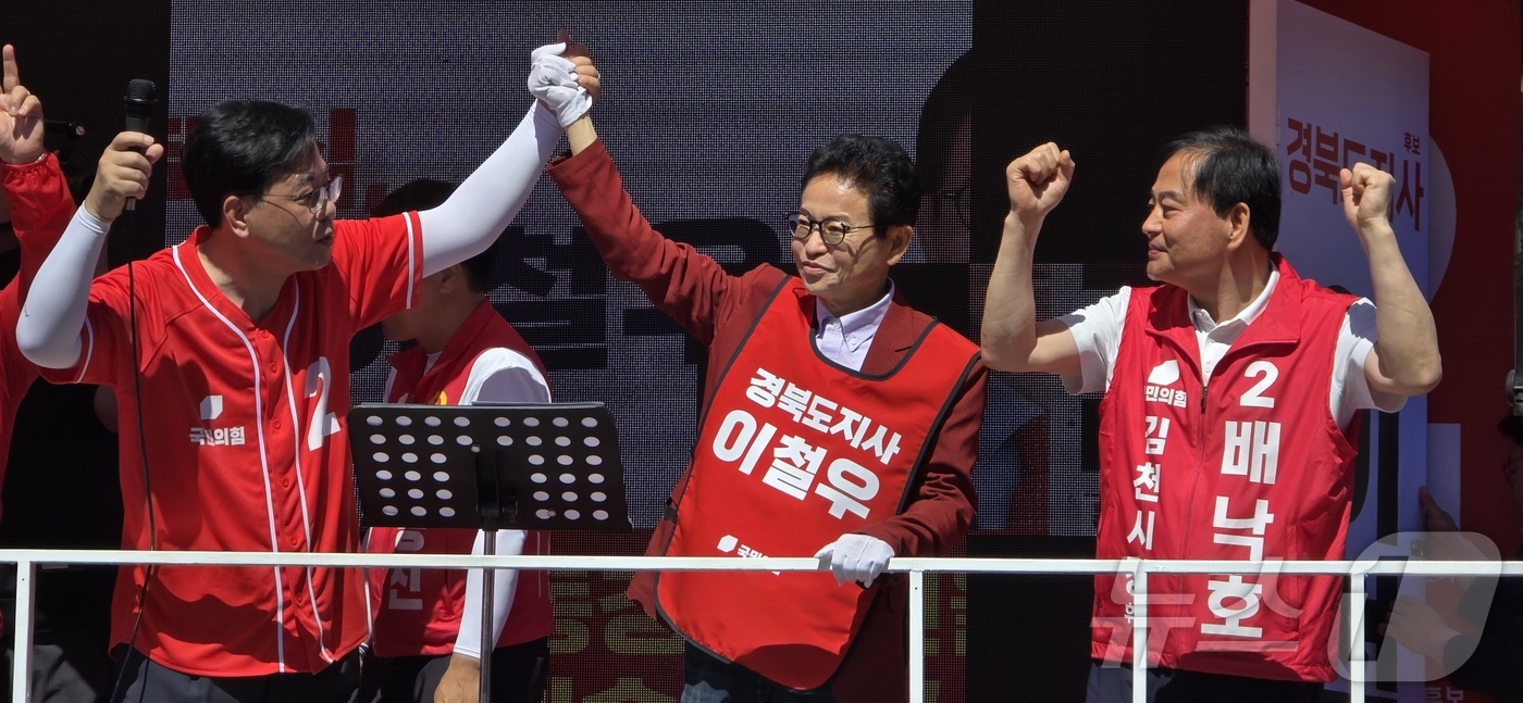 (김천=뉴스1) 정우용 기자 = 송언석 국힘 원내대표(왼쪽)가 30일 경북 김천에서 열린 합동유세에서 이철우 경북지사 후보(가운데), 배낙호 김천시장 후보와 손을 들어 환호에 답하 …