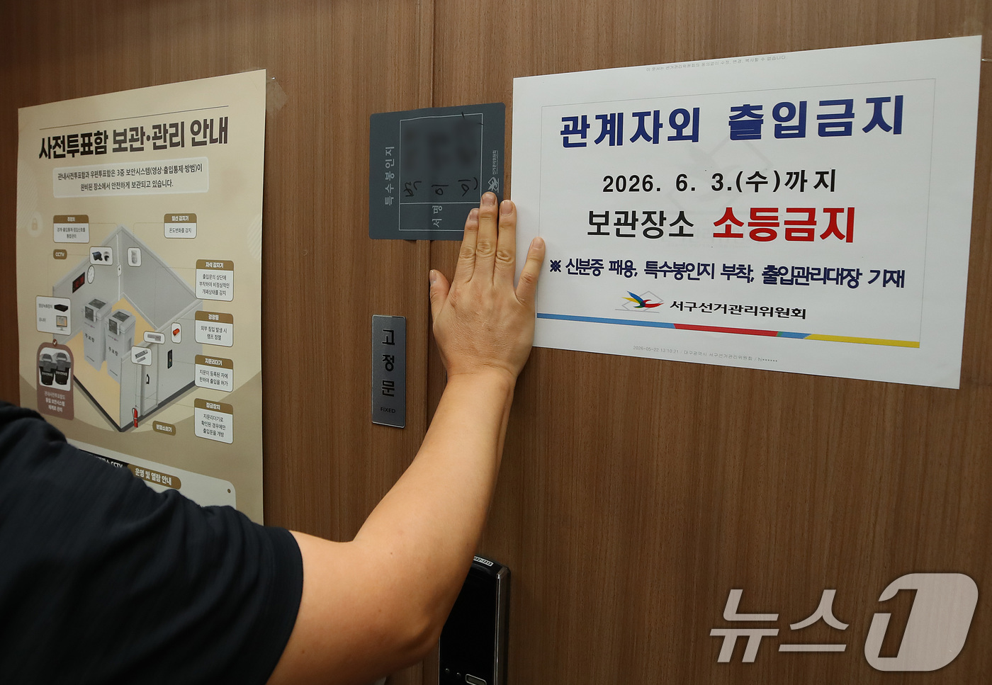 (대구=뉴스1) 공정식 기자 = 제9회 전국동시지방선거 사전투표가 종료된 30일 오후 대구 서구선거관리위원회에서 선관위 관계자가 관내사전투표함 보관장소 출입문을 특수봉인지로 봉인하 …