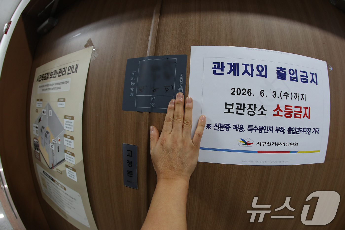 (대구=뉴스1) 공정식 기자 = 제9회 전국동시지방선거 사전투표가 종료된 30일 오후 대구 서구선거관리위원회에서 선관위 관계자가 관내사전투표함 보관장소 출입문을 특수봉인지로 봉인하 …
