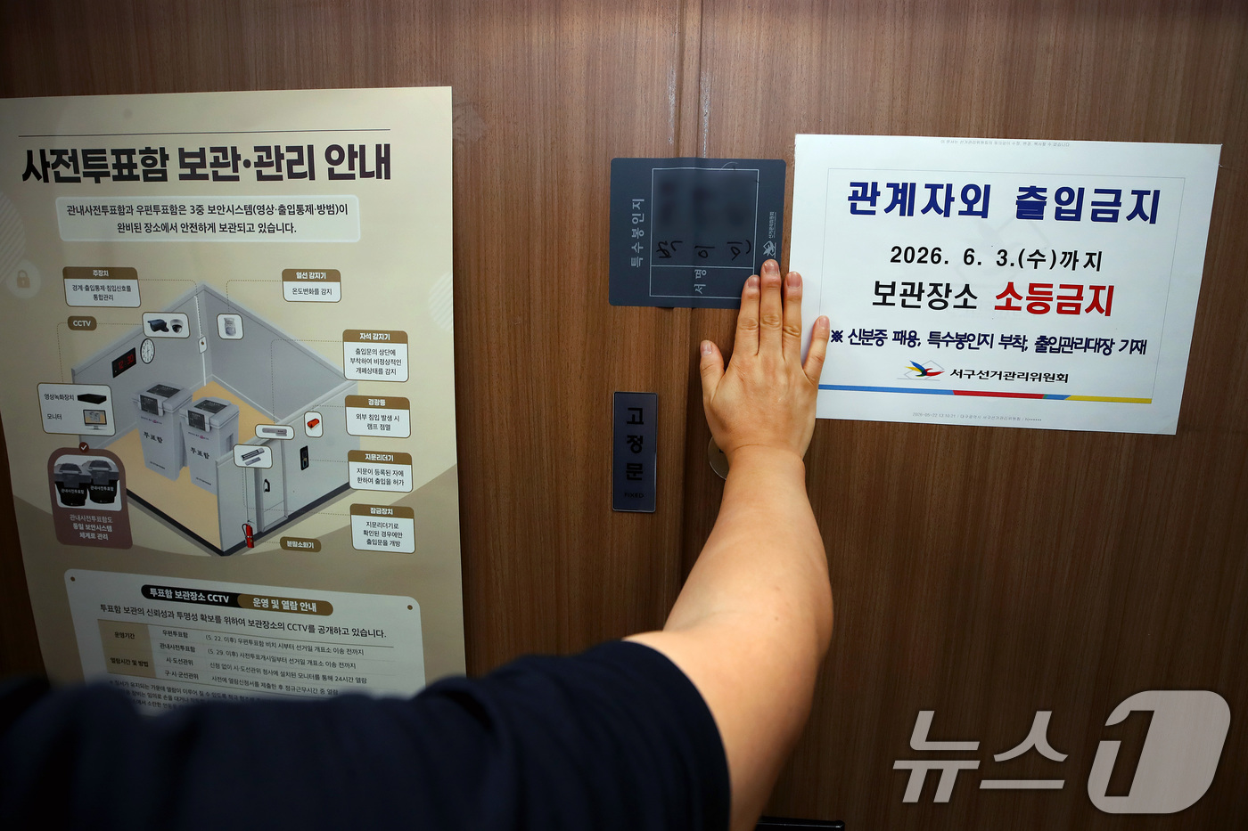 (대구=뉴스1) 공정식 기자 = 제9회 전국동시지방선거 사전투표가 종료된 30일 오후 대구 서구선거관리위원회에서 선관위 관계자가 관내사전투표함 보관장소 출입문을 특수봉인지로 봉인하 …