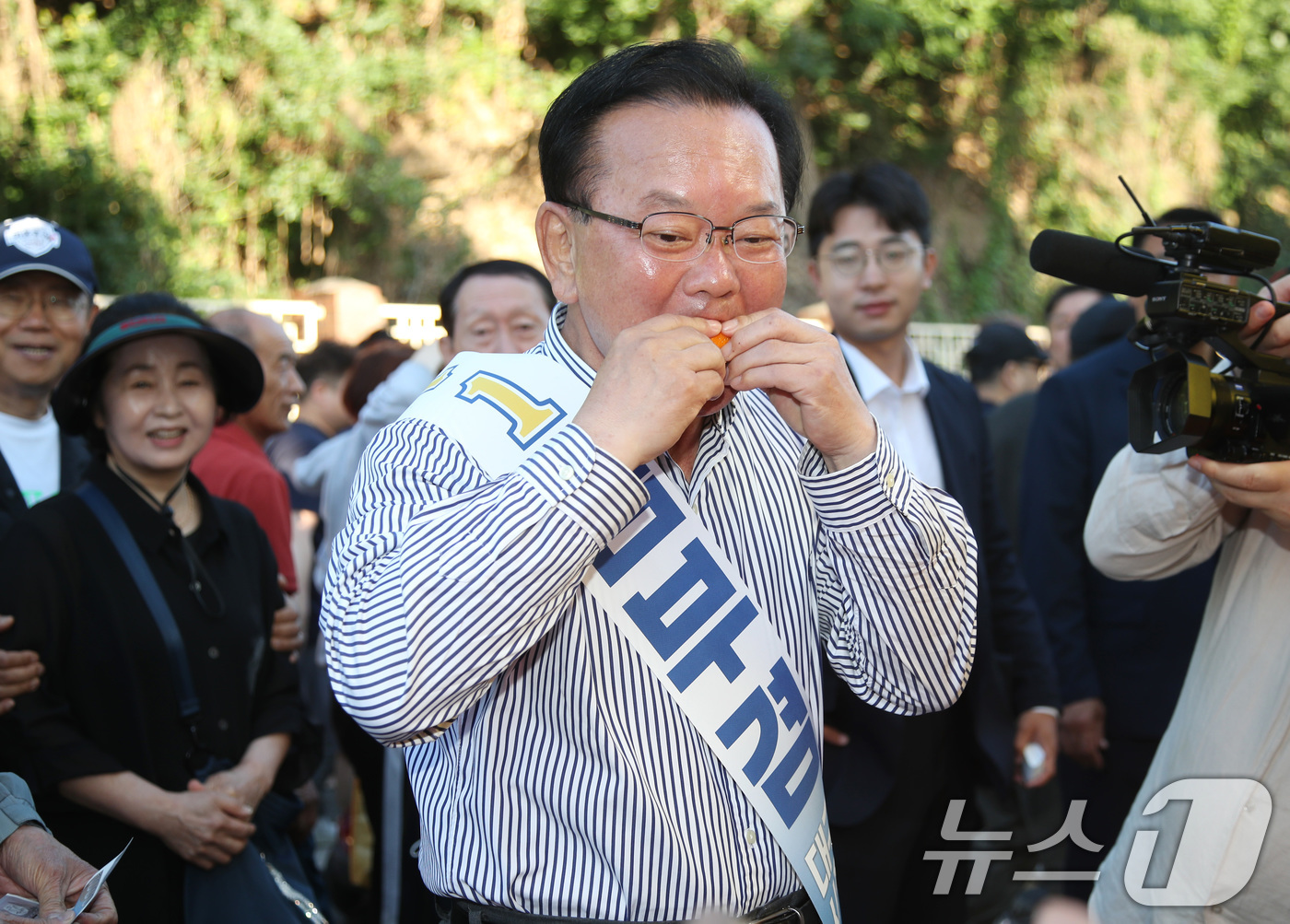 (대구=뉴스1) 공정식 기자 = 김부겸 더불어민주당 대구시장 후보가 31일 오전 대구 중구 달성공원 새벽시장을 찾아 시식용 오렌지를 맛보고 있다. 2026.5.31/뉴스1