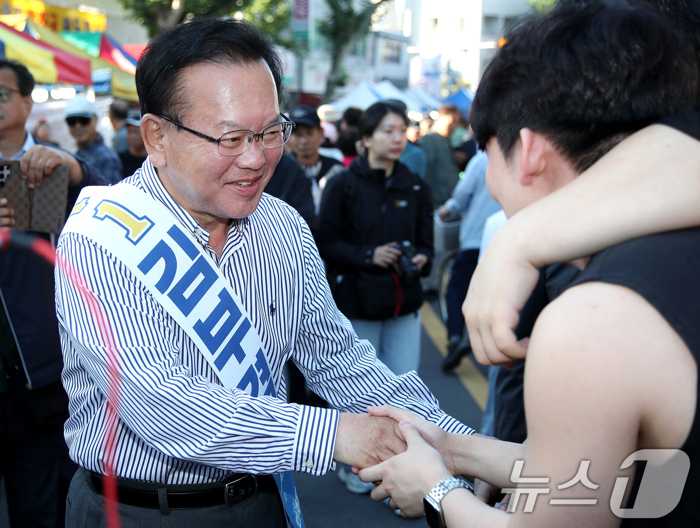 (대구=뉴스1) 공정식 기자 = 김부겸 더불어민주당 대구시장 후보가 31일 오전 대구 중구 달성공원 새벽시장을 찾아 지역 청년들과 인사 나누고 있다. 2026.5.31/뉴스1