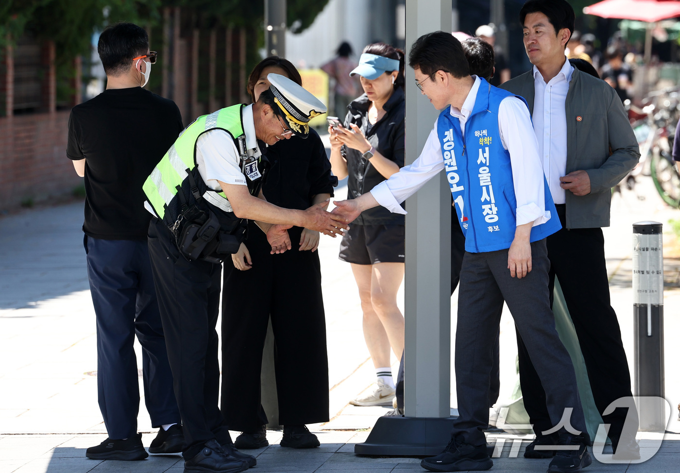 (서울=뉴스1) 최지환 기자 = 정원오 더불어민주당 서울시장 후보가 31일 오전 서울 양천구 파리공원에서 도보유세를 하며 경찰관과 악수를 하고 있다. 2026.5.31/뉴스1