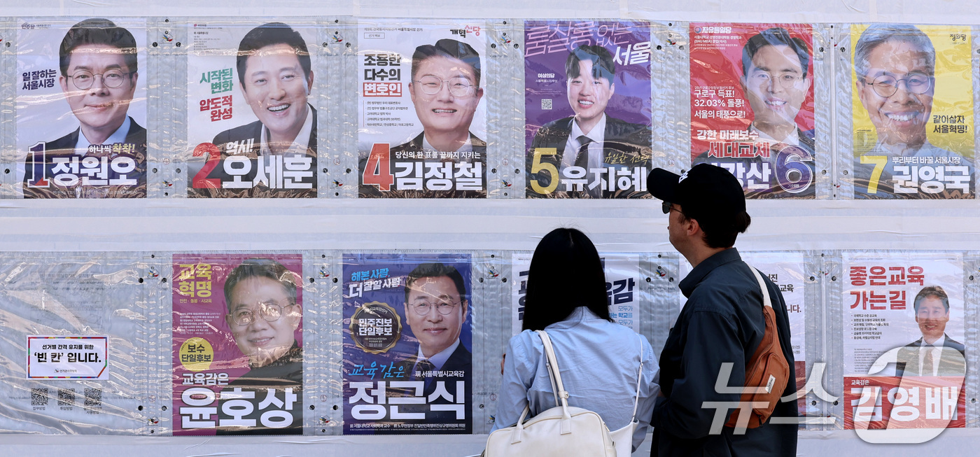 (서울=뉴스1) 구윤성 기자 = 제9회 전국동시지방선거일을 사흘 앞둔 31일 시민들이 서울 중구 명동 일대에 붙은 선거벽보를 살피고 있다.  2026.5.31/뉴스1