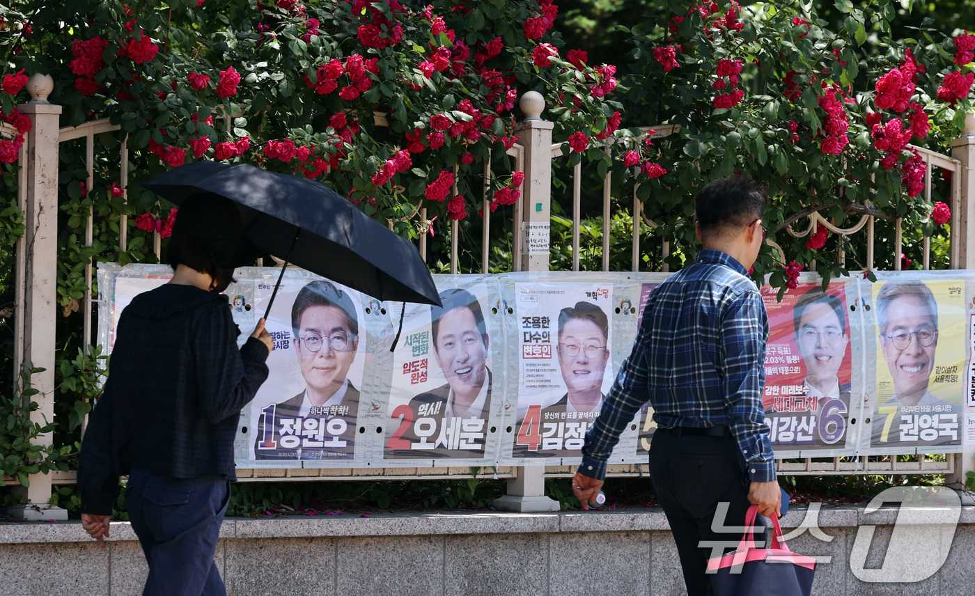 (서울=뉴스1) 구윤성 기자 = 제9회 전국동시지방선거일을 사흘 앞둔 31일 시민들이 서울 중구 명동 일대에 붙은 선거벽보를 살피고 있다. 2026.5.31/뉴스1
