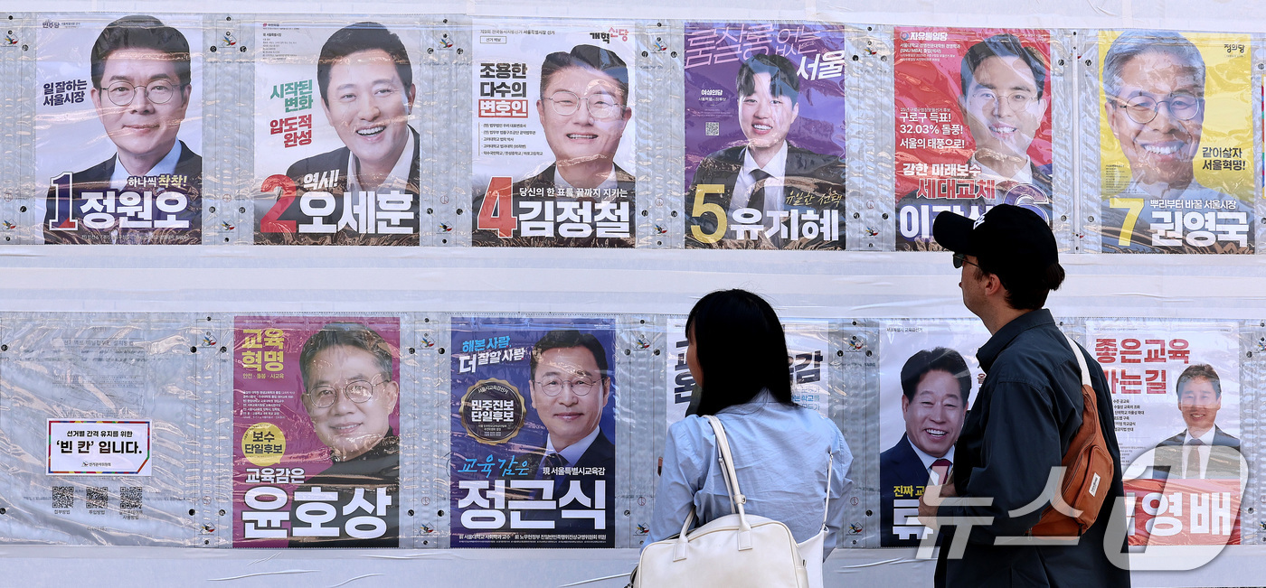 (서울=뉴스1) 구윤성 기자 = 제9회 전국동시지방선거일을 사흘 앞둔 31일 시민들이 서울 중구 명동 일대에 붙은 선거벽보를 살피고 있다. 2026.5.31/뉴스1