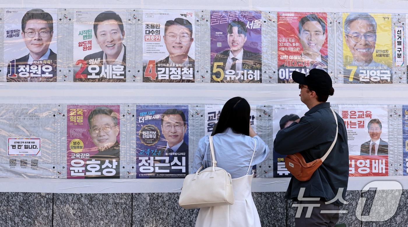 (서울=뉴스1) 구윤성 기자 = 제9회 전국동시지방선거일을 사흘 앞둔 31일 시민들이 서울 중구 명동 일대에 붙은 선거벽보를 살피고 있다. 2026.5.31/뉴스1