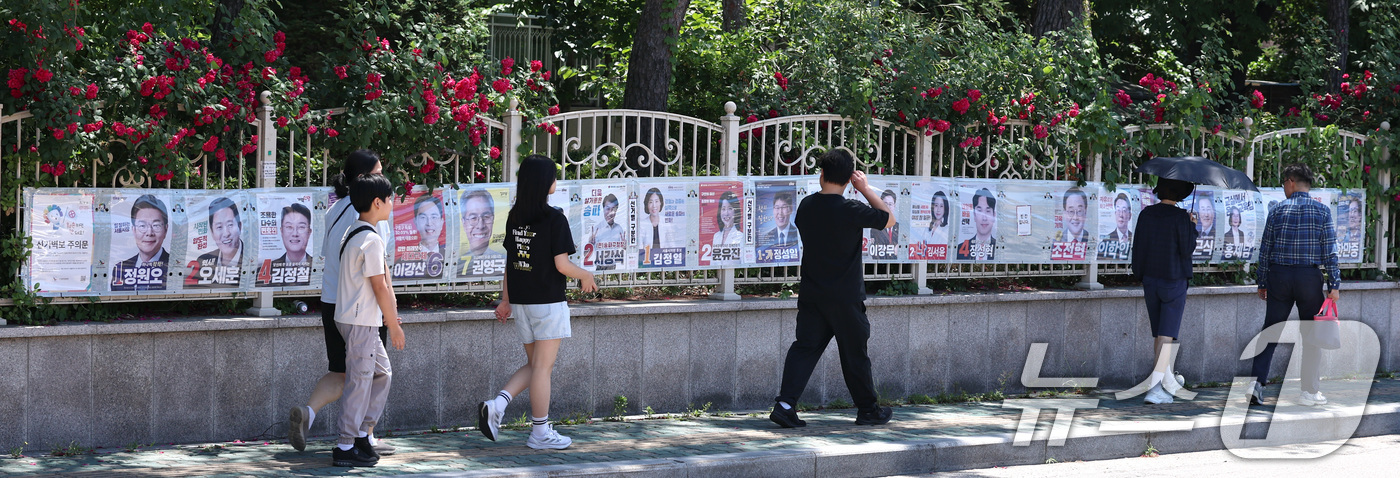 (서울=뉴스1) 구윤성 기자 = 제9회 전국동시지방선거일을 사흘 앞둔 31일 시민들이 서울 송파구 풍납동 일대에 붙은 선거벽보를 살피고 있다. 2026.5.31/뉴스1
