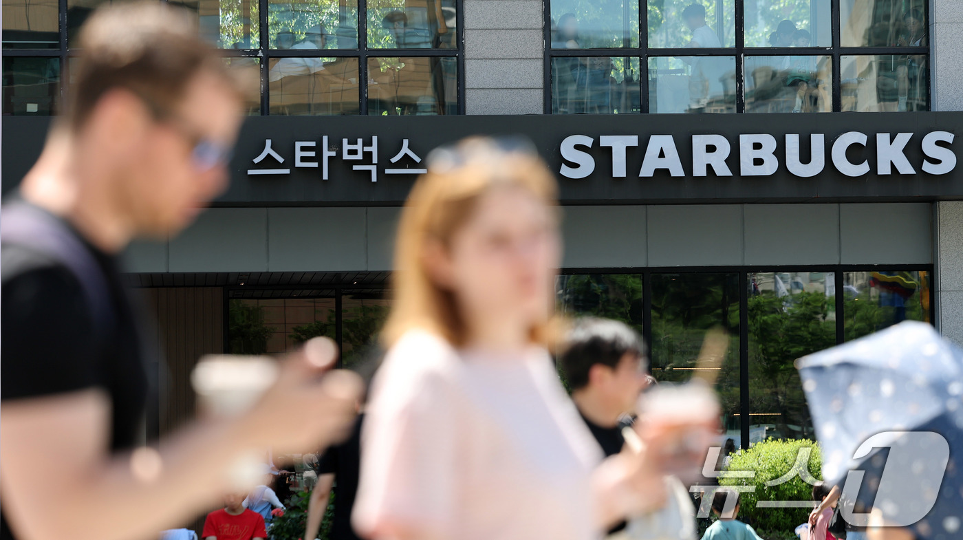(서울=뉴스1) 박지혜 기자 = 31일 서울 시내 한 스타벅스 매장 앞으로 외국인 관광객이 지나가고 있다.스타벅스코리아 최대 주주인 이마트는 '5·18 탱크데이' 논란에 따른 고객 …