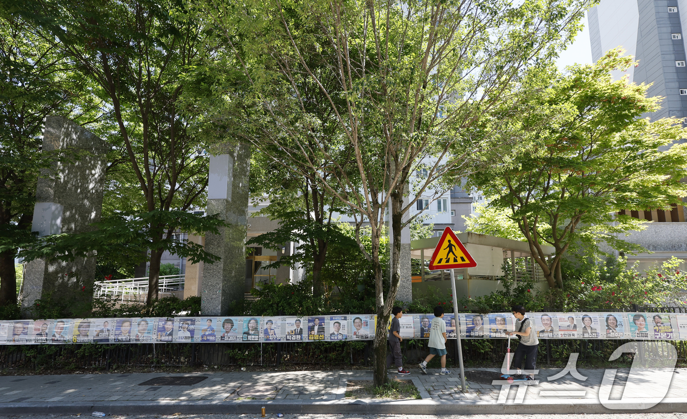 (광주=뉴스1) 김태성 기자 = 제9회 전국동시지방선거일을 사흘 앞둔 31일 시민들이 광주시 광산구 장덕동에 붙은 28장의 선거벽보를 지켜보고 있다. 2026.5.31/뉴스1
