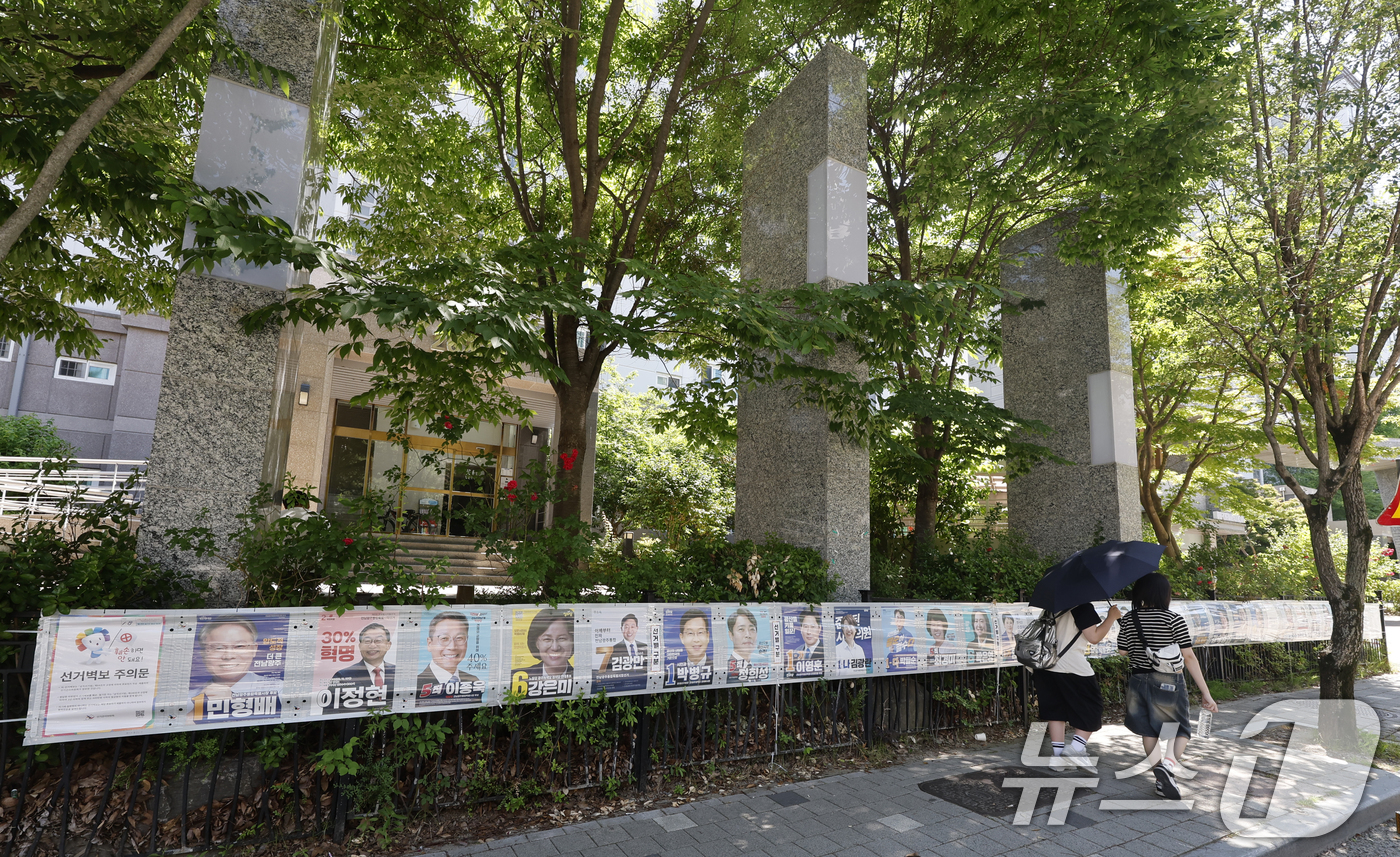 (광주=뉴스1) 김태성 기자 = 제9회 전국동시지방선거일을 사흘 앞둔 31일 시민들이 광주시 광산구 장덕동에 붙은 28장의 선거벽보를 지켜보고 있다. 2026.5.31/뉴스1