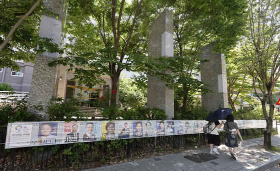28장 선거벽보 지켜보는 시민들