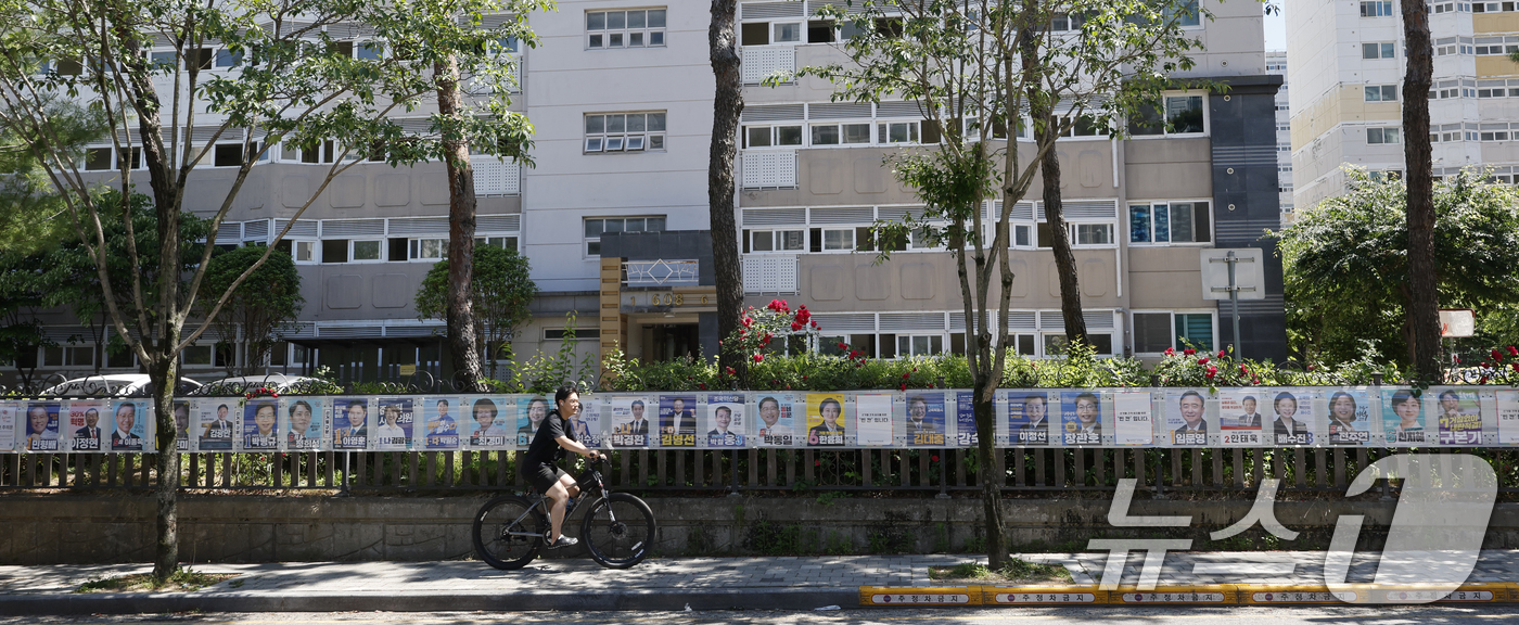 (광주=뉴스1) 김태성 기자 = 제9회 전국동시지방선거일을 사흘 앞둔 31일 시민들이 광주시 광산구 장덕동에 붙은 28장의 선거벽보를 지켜보고 있다. 2026.5.31/뉴스1