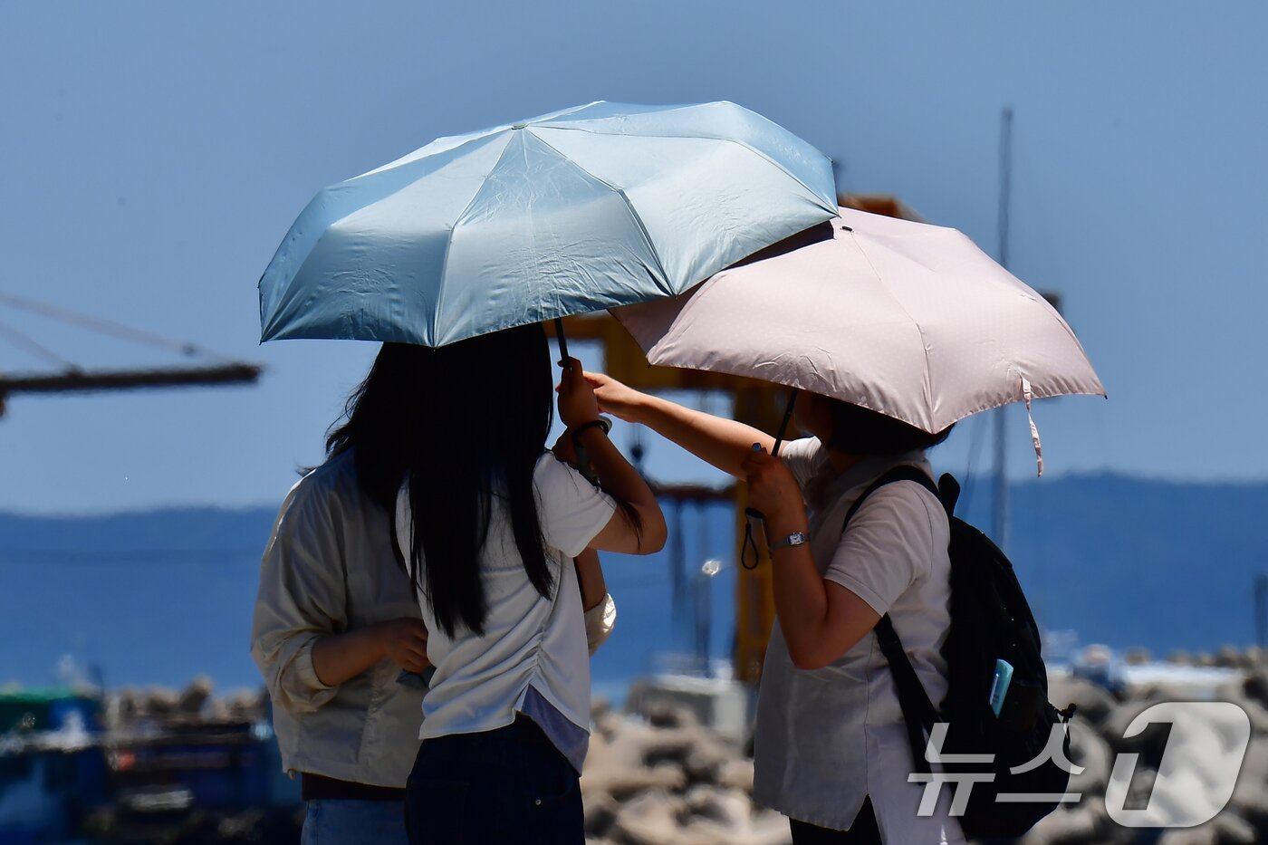 본문 이미지 - 31일 오후 경북 포항시 북구 영일대해수욕장에서 양산을 쓴 관광객들이걸어가고 있다. 2026.5.31 ⓒ 뉴스1 최창호 기자