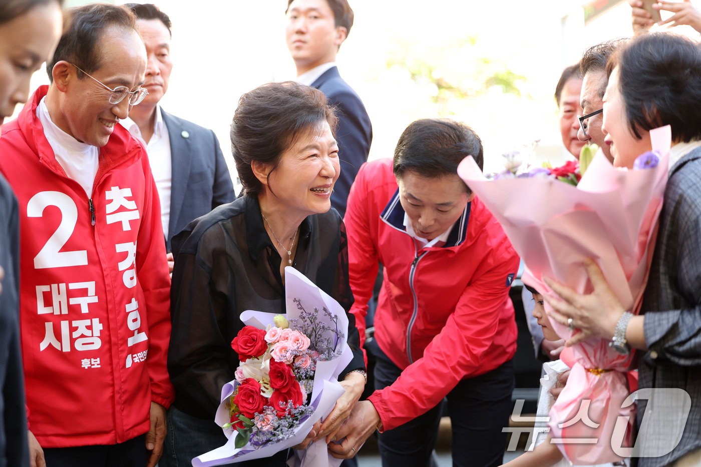 (대구=뉴스1) 공정식 기자 = 박근혜 전 대통령과 추경호 국민의힘 대구시장 후보가 31일 오후 대구 중구 서문시장을 찾아 환영의 꽃다발을 받고 있다. 2026.5.31/뉴스1