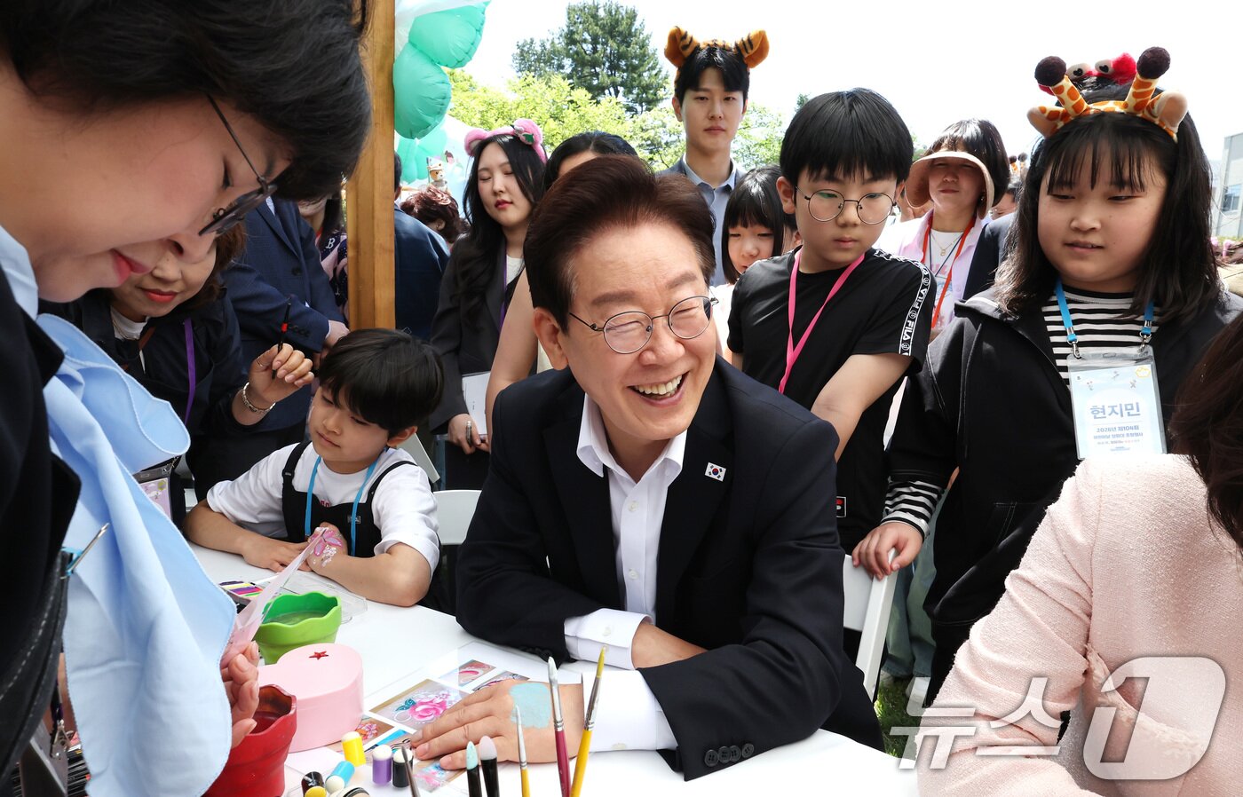 본문 이미지 - 이재명 대통령과 김혜경 여사가 5일 청와대 녹지원에서 열린 2026 어린이날 초청행사에 참석한 어린이들과 함께 손등에 페이스 페인팅을 받고 있다. 2026.5.5 ⓒ 뉴스1 허경 기자
