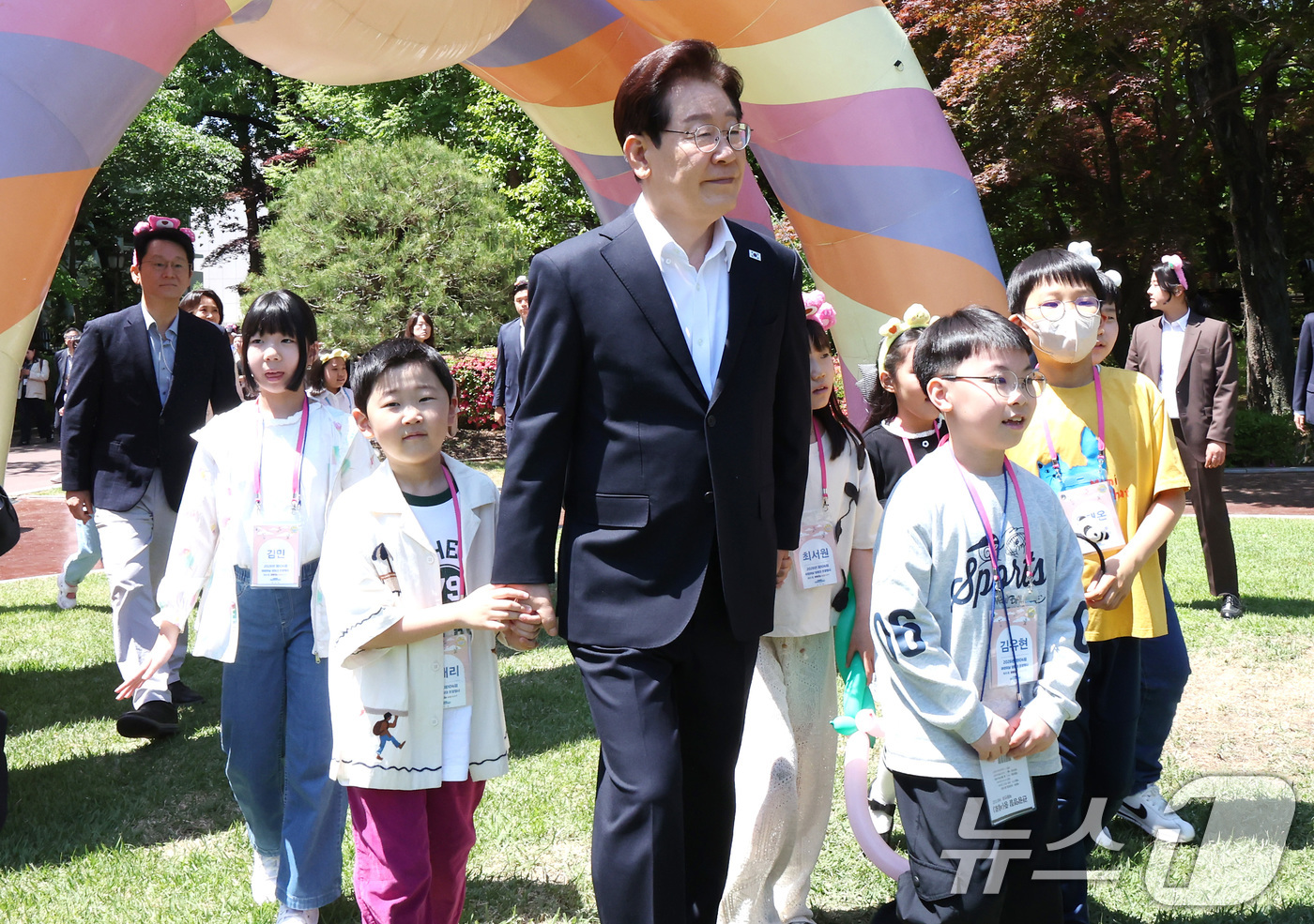 (서울=뉴스1) 허경 기자 = 이재명 대통령과 김혜경 여사가 5일 청와대에서 열린 2026 어린이날 초청행사에 참석한 어린이들과 녹지원으로 이동하고 있다.   2026.5.5/뉴스 …