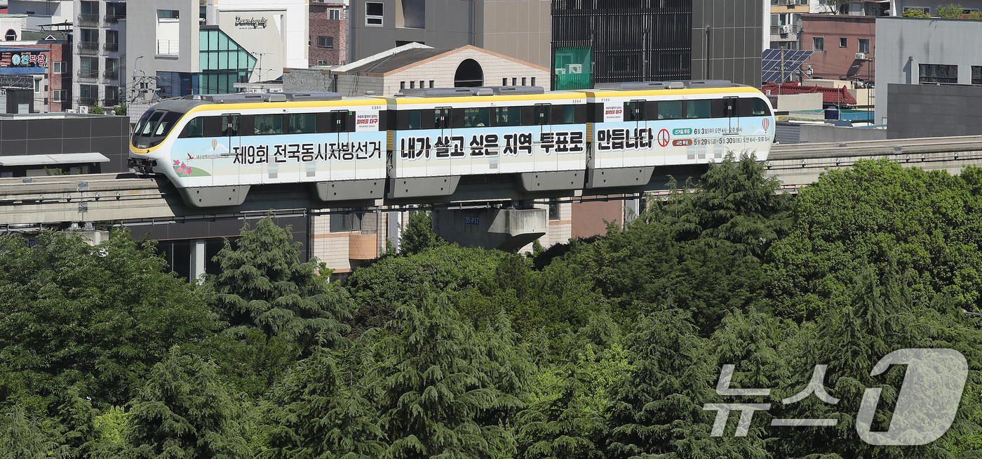 (대구=뉴스1) 공정식 기자 = 제9회 전국동시지방선거가 29일 앞으로 다가온 5일 대구도시철도 3호선 '선거 열차'가 녹음 짙어가는 도심을 지나고 있다.대구시선관위는 지방선거를 …