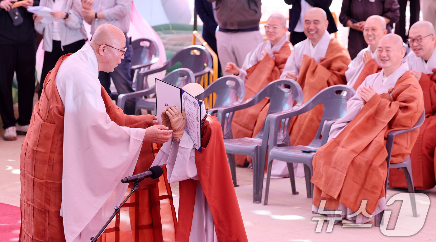 (서울=뉴스1) 박지혜 기자 = 6일 서울 종로구 조계사 대웅전 앞마당에서 열린 ‘2026 부처님오신날 기념 로봇 수계식’에서 휴머노이드 로봇 ‘가비’스님이 수계증을 받던 중 얼굴 …