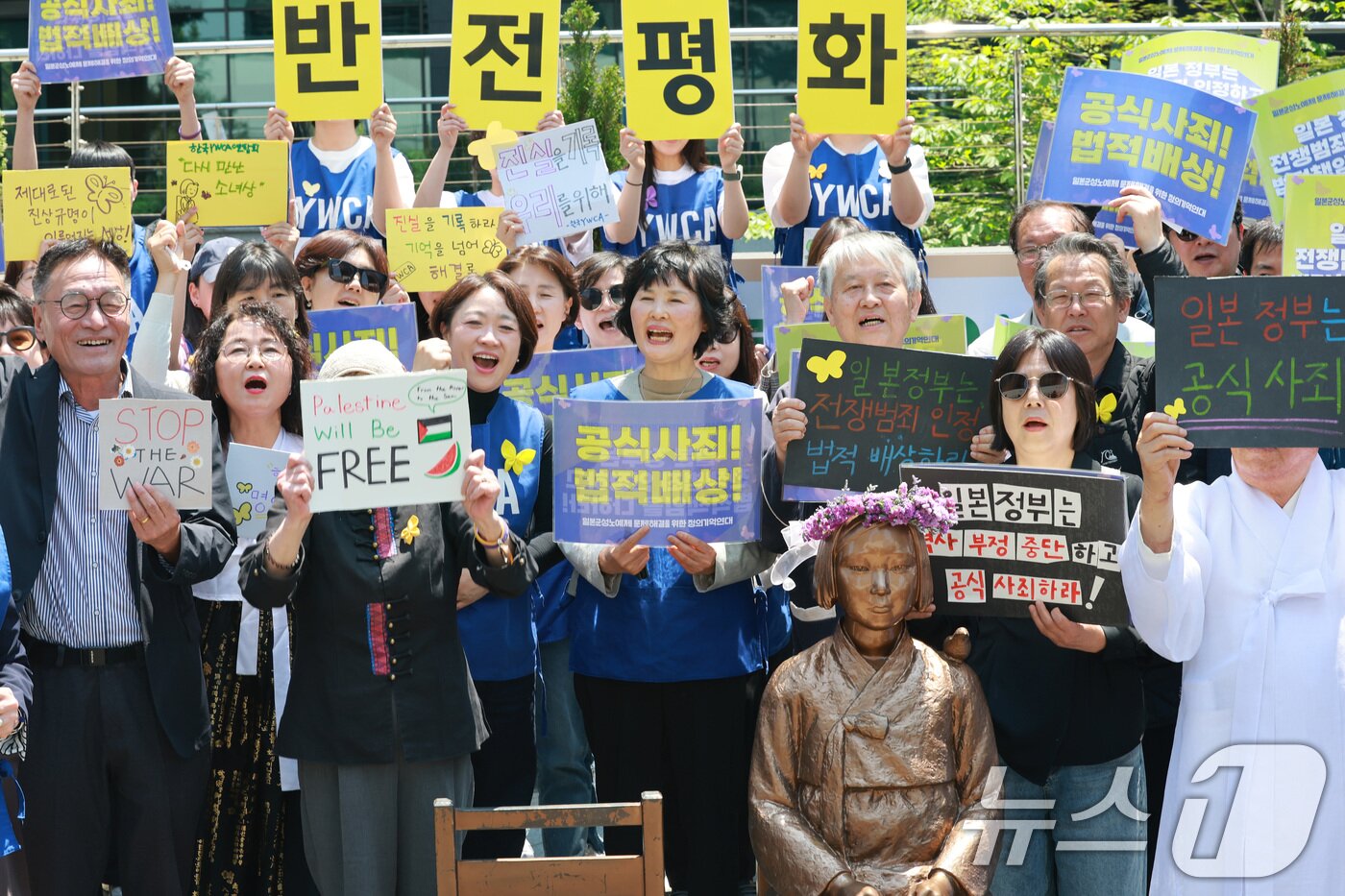 본문 이미지 - 6일 서울 종로구 옛 주한 일본대사관 앞에서 열린 제1751차 일본군 성노예제 문제해결을 위한 정기 수요시위에서 참석자들이 6년 여 만에 바리케이드가 철거된 평화의 소녀상을 반기는 퍼포먼스를 펼치고 있다. 2026.5.6 ⓒ 뉴스1 임세영 기자