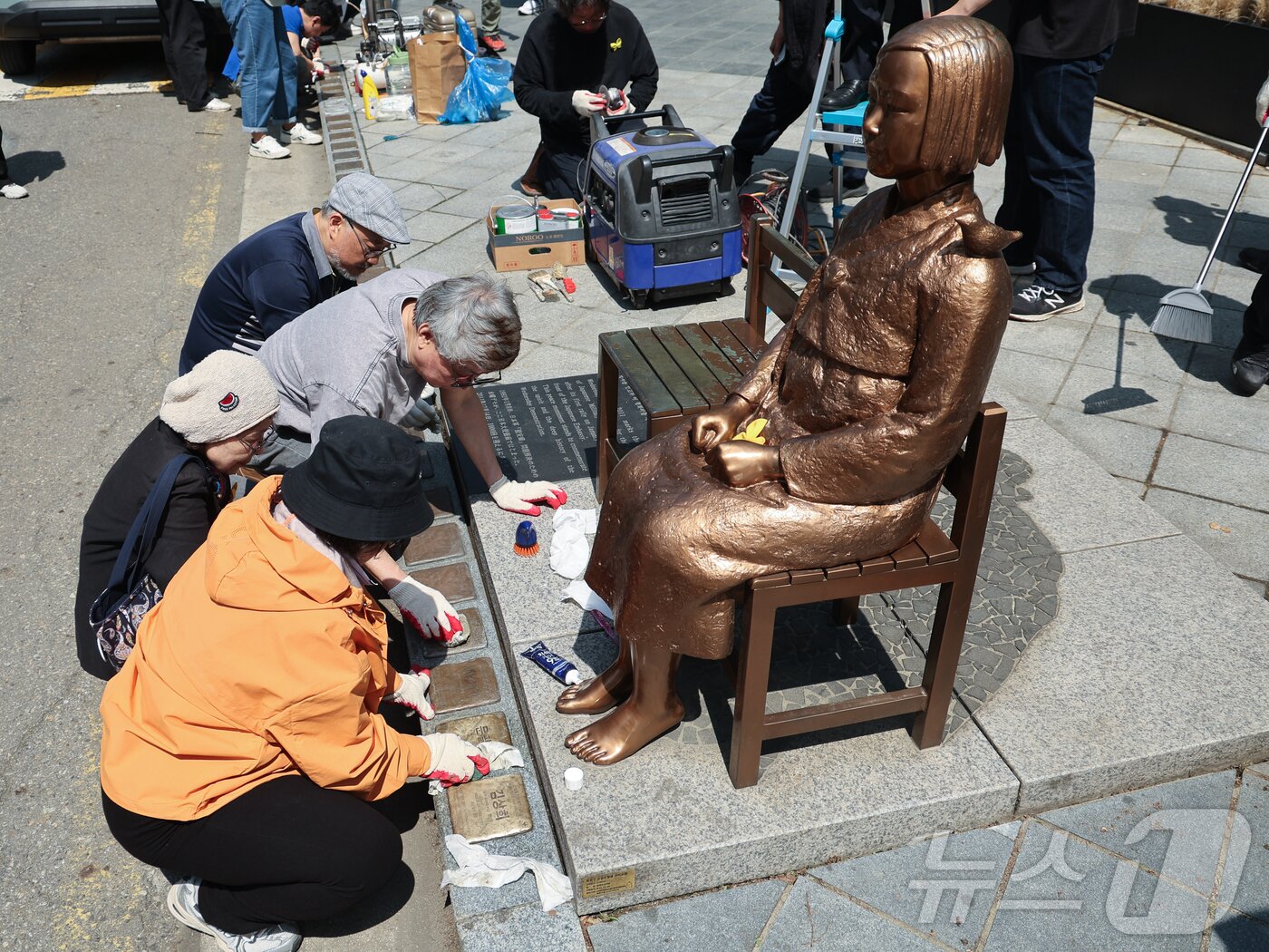 본문 이미지 - 6일 서울 종로구 옛 주한 일본대사관 앞 평화의 소녀상에서 제작자와 관계자들이 보수 작업을 하고 있다. 소녀상을 둘러싼 경찰 바리케이드는 이날 6년만에 철거됐다. ⓒ 뉴스1 이종수 인턴기자