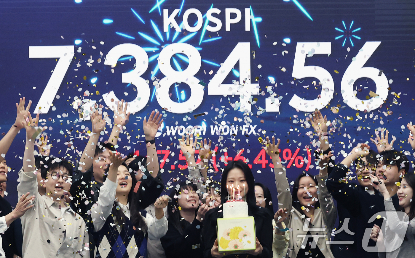 (서울=뉴스1) 오대일 기자 = 코스피가 전인미답의 7000선 고지를 돌파한 6일 오후 서울 중구 우리은행 본점 딜링룸에서 직원들이 코스피 종가를 배경으로 축하 세리머니를 하고 있 …