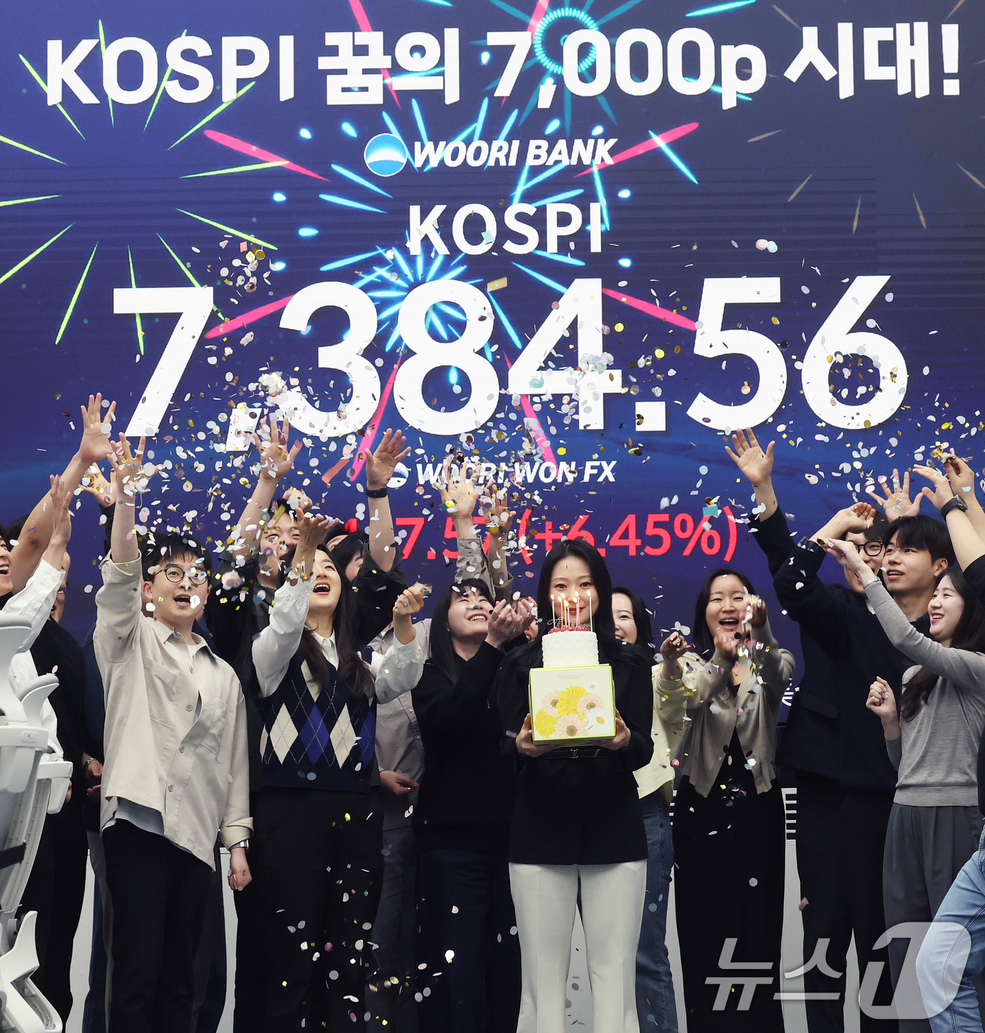 (서울=뉴스1) 오대일 기자 = 코스피가 전인미답의 7000선 고지를 돌파한 6일 오후 서울 중구 우리은행 본점 딜링룸에서 직원들이 코스피 종가를 배경으로 축하 세리머니를 하고 있 …