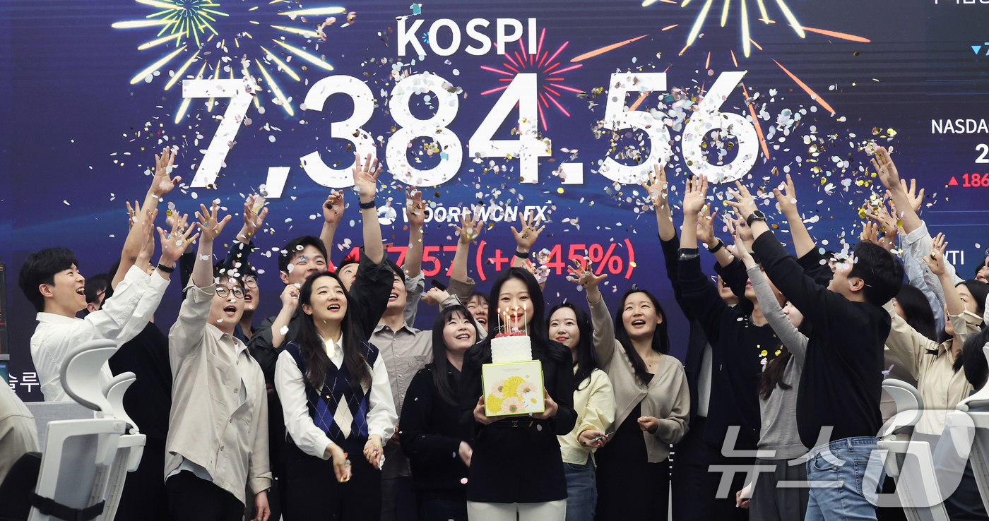 (서울=뉴스1) 오대일 기자 = 코스피가 전인미답의 7000선 고지를 돌파한 6일 오후 서울 중구 우리은행 본점 딜링룸에서 직원들이 코스피 종가를 배경으로 축하 세리머니를 하고 있 …