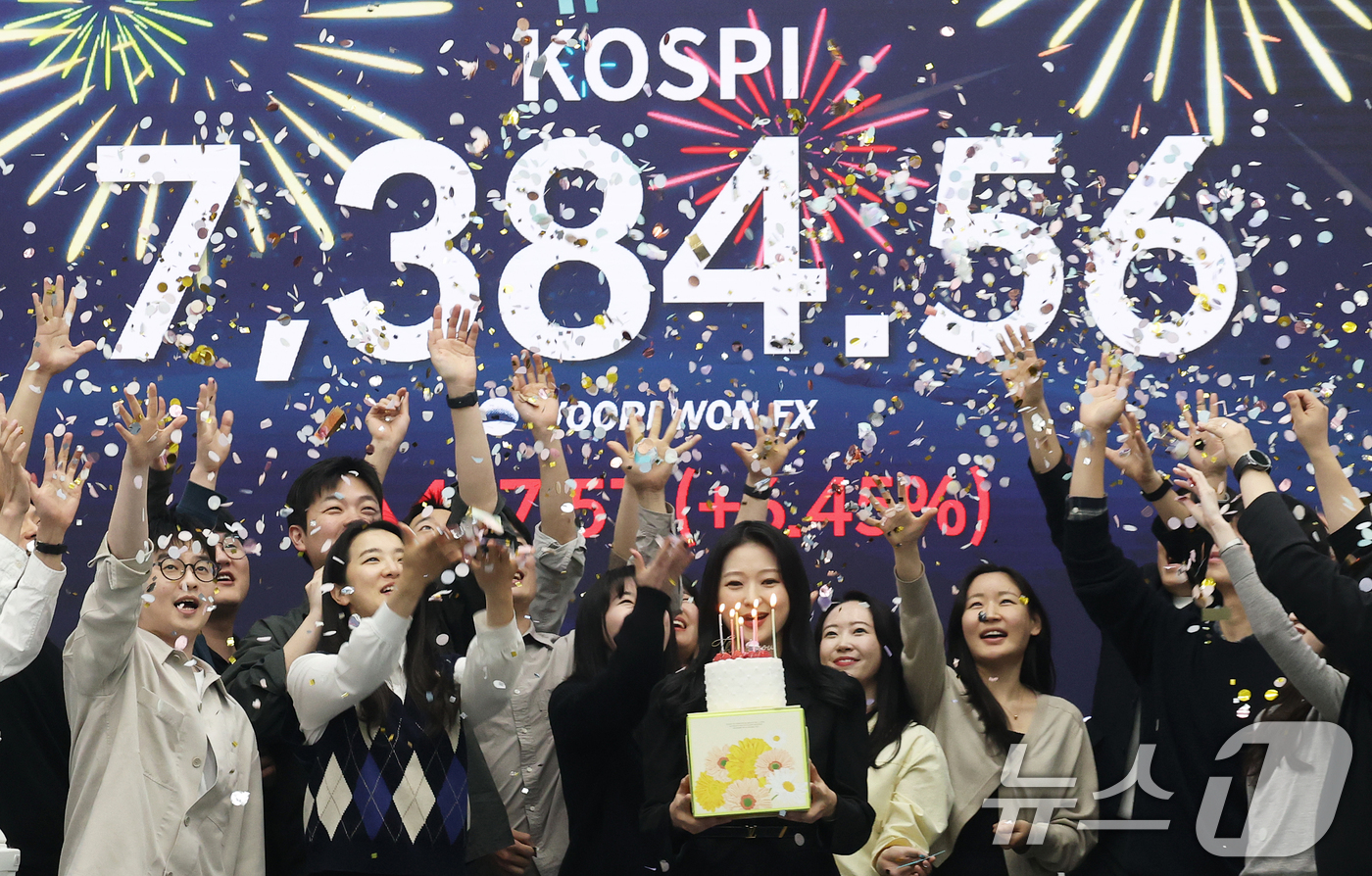(서울=뉴스1) 오대일 기자 = 코스피가 전인미답의 7000선 고지를 돌파한 6일 오후 서울 중구 우리은행 본점 딜링룸에서 직원들이 코스피 종가를 배경으로 축하 세리머니를 하고 있 …