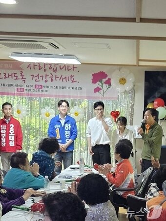 본문 이미지 - 부산 북구갑 국회의원 선거에 출마한 하정우 더불어민주당 후보와 한동훈 무소속 후보, 한 후보의 아내 진은정 변호사가 북구 한 아파트 경로당에서 어르신들에게 인사하는 모습. (독자제공) 2026.5.7 ⓒ 뉴스1