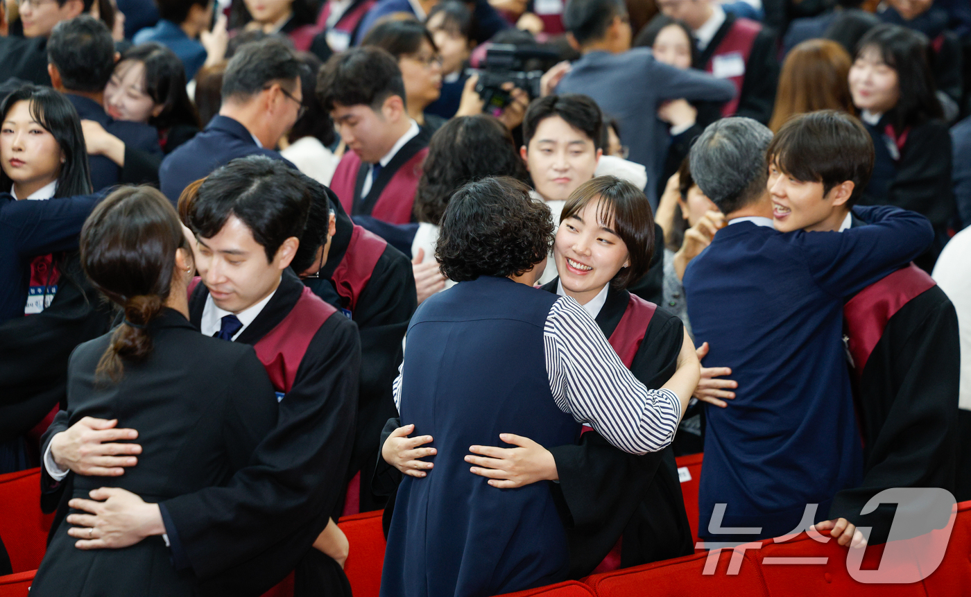 (과천=뉴스1) 안은나 기자 = 7일 경기 과천시 정부과천청사 법무부에서 열린 2026 신임검사 임관식에서 신임검사들에게 법복을 입혀준 가족들이 서로 포옹하고 있다. 2026.5. …