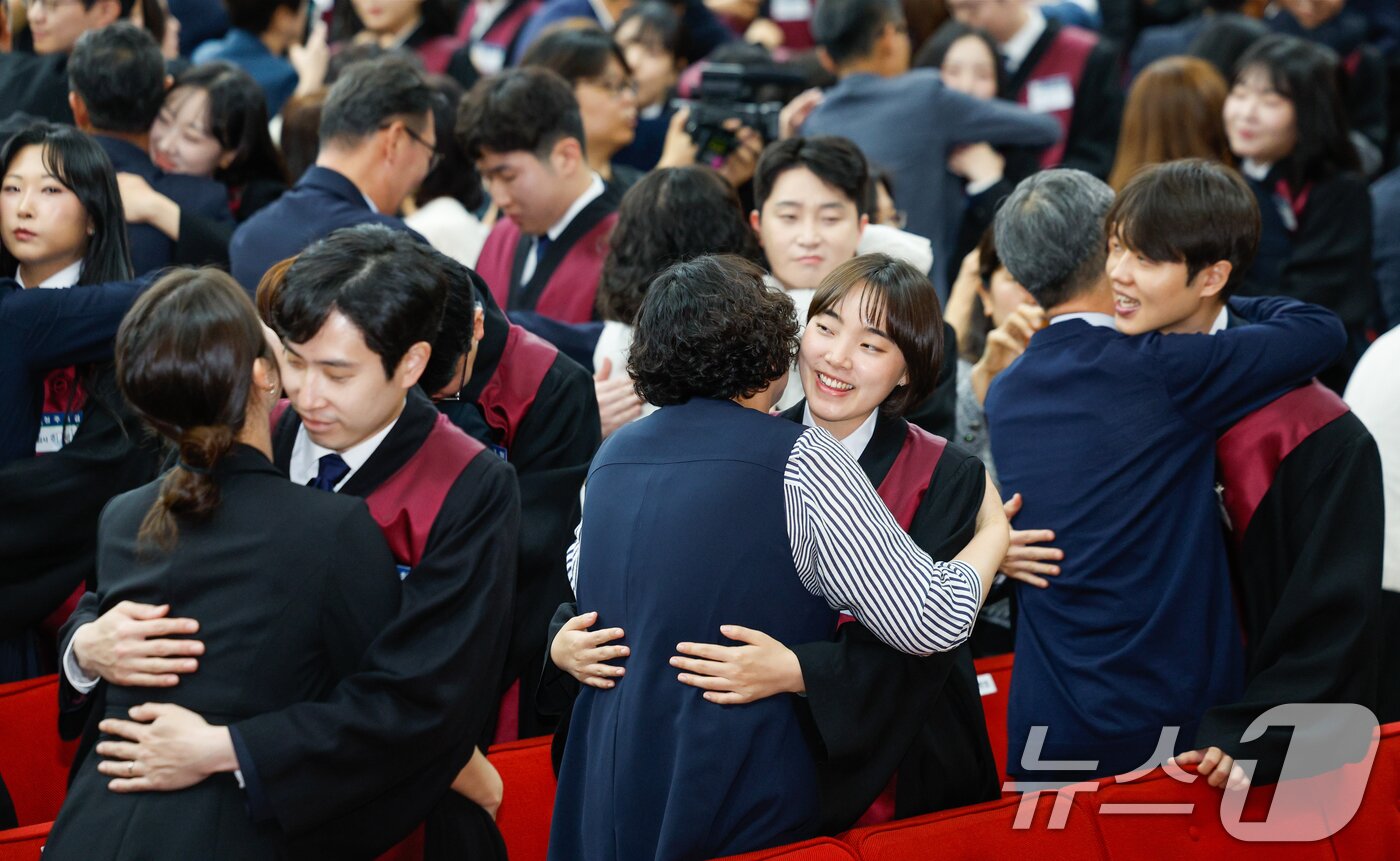 본문 이미지 - 7일 경기 과천시 정부과천청사 법무부에서 열린 2026 신임검사 임관식에서 신임검사들에게 법복을 입혀준 가족들이 서로 포옹하고 있다. 2026.5.7 ⓒ 뉴스1 안은나 기자