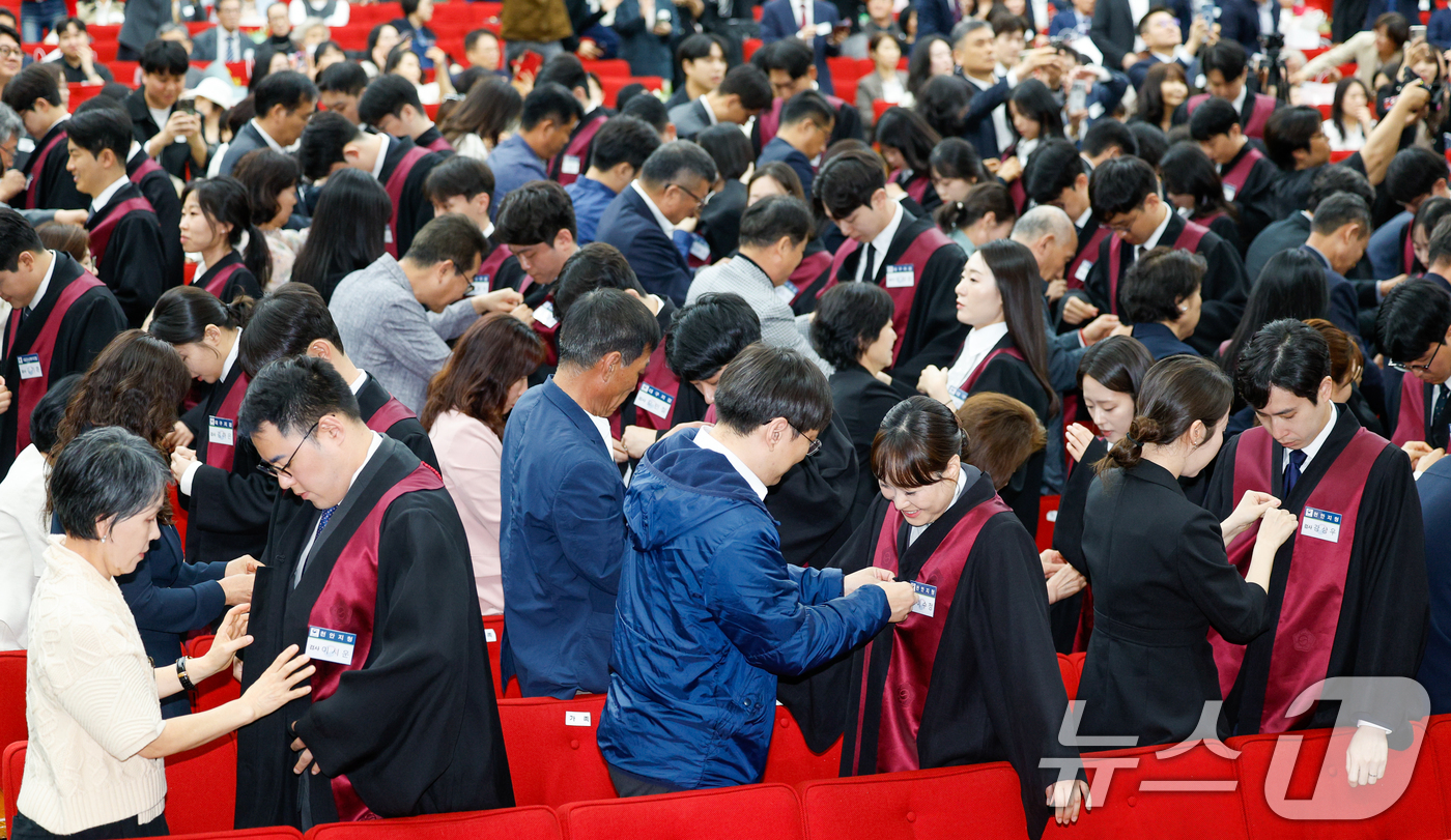 (과천=뉴스1) 안은나 기자 = 7일 경기 과천시 정부과천청사 법무부에서 열린 2026 신임검사 임관식에서 신임검사들에게 가족들이 법복을 입혀주고 있다. 2026.5.7/뉴스1
