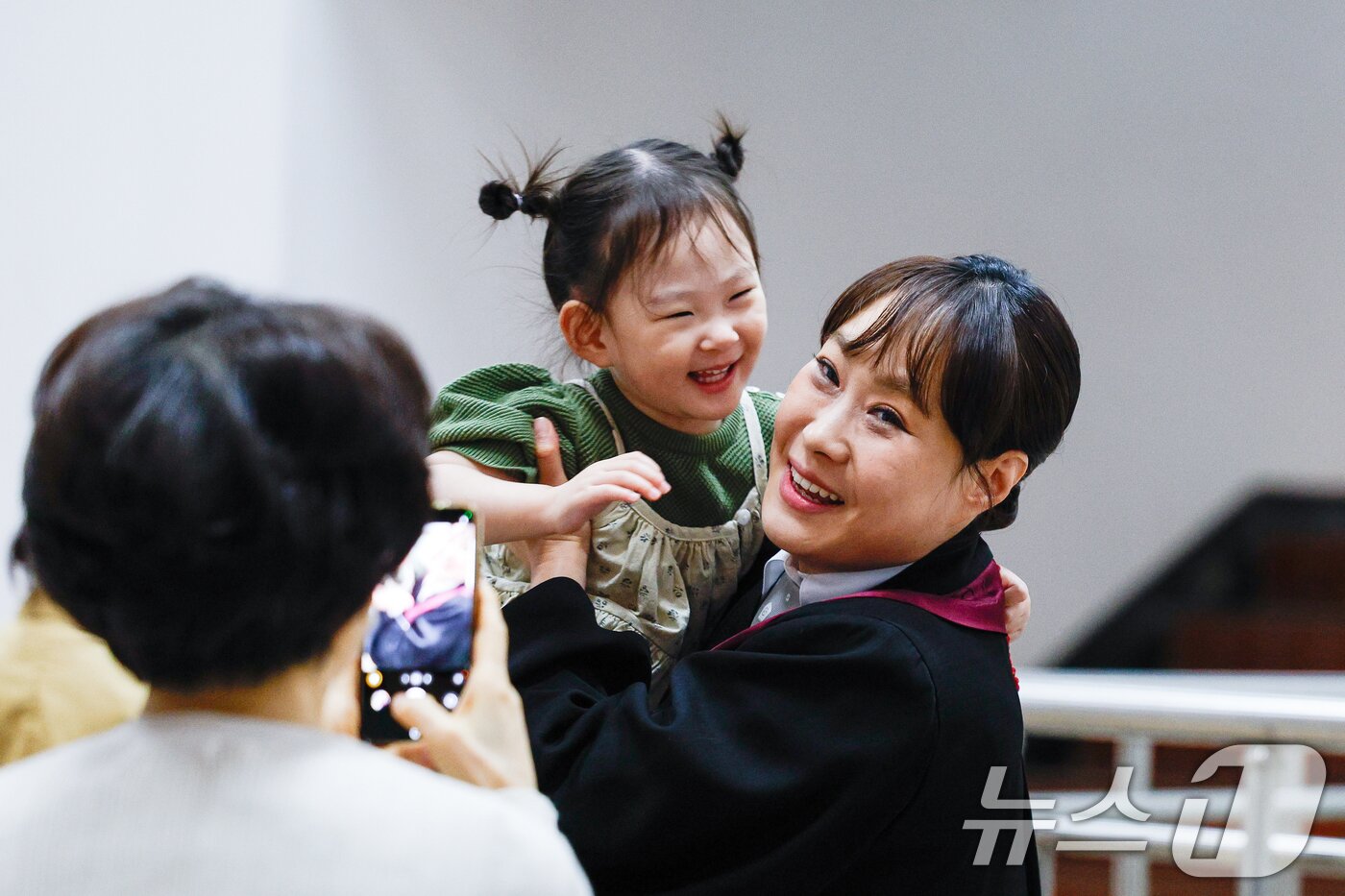 본문 이미지 - 7일 경기 과천시 정부과천청사 법무부에서 2026 신임검사 임관식이 열린 가운데 한 신임검사가 딸을 안고 있다. 2026.5.7 ⓒ 뉴스1 안은나 기자