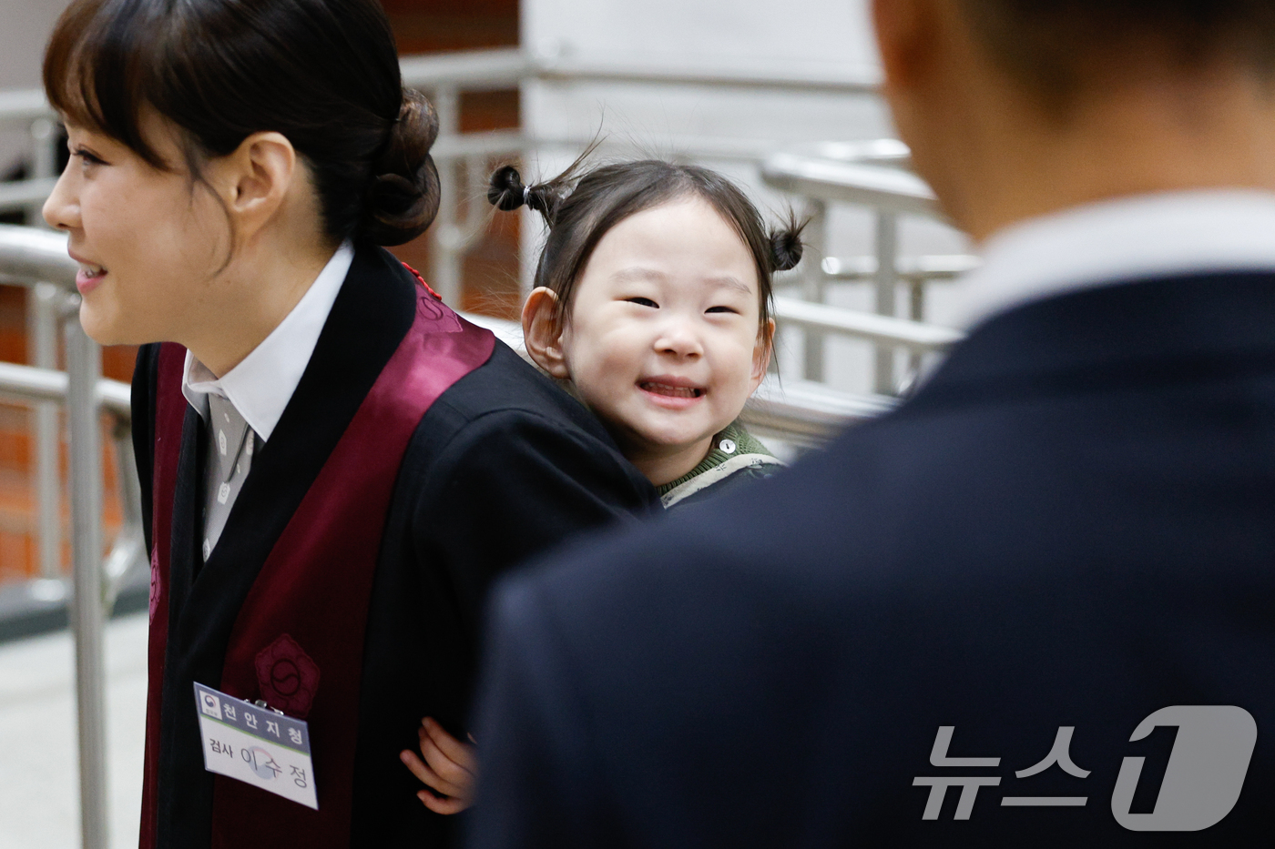 (과천=뉴스1) 안은나 기자 = 7일 경기 과천시 정부과천청사 법무부에서 2026 신임검사 임관식이 열린 가운데 한 신임검사가 딸을 등에 업고 있다. 2026.5.7/뉴스1