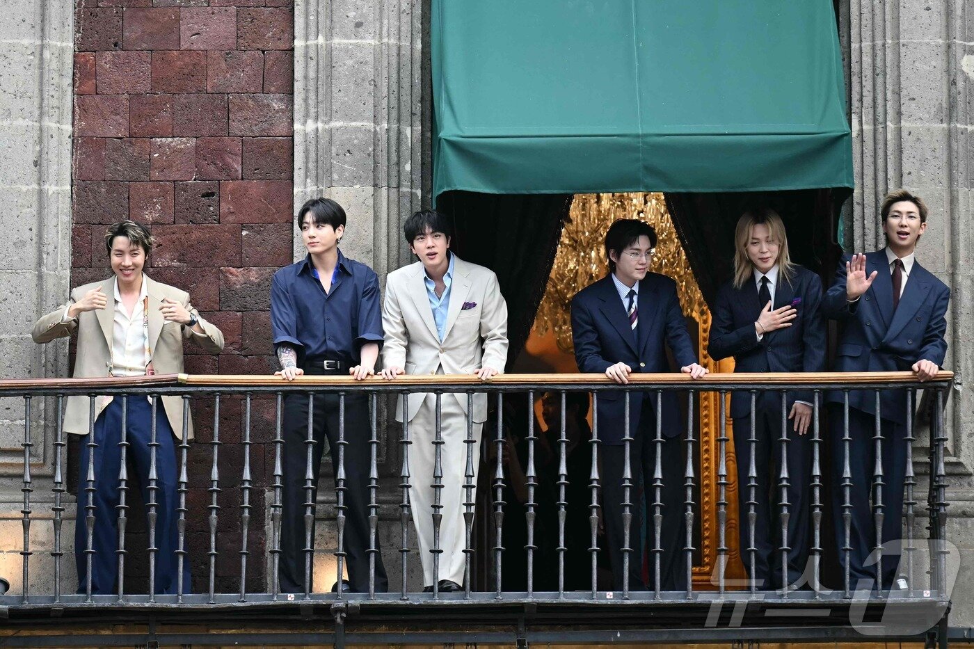 본문 이미지 - 그룹 방탄소년단(BTS)이 6일(현지시간) 멕시코시티 소칼로 광장에 위치한 대통령궁 발코니에서 아미와 시민들에게 인사하고 있다. ⓒ AFP=뉴스1