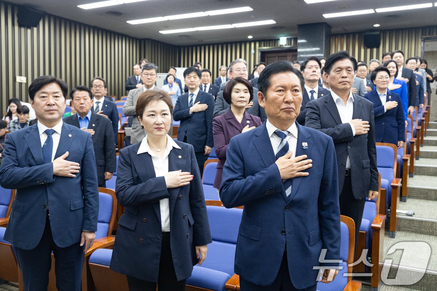 본문 이미지 - 정청래 더불어민주당 대표를 비롯한  의원들이 7일 서울 여의도 국회에서 열린 의원총회에서 국민의례를 하고 있다. 2026.5.7 ⓒ 뉴스1 유승관 기자