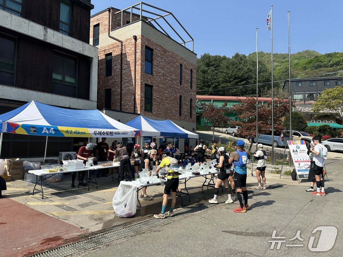 본문 이미지 - 2026 동두천 코리아 50k 마지막 체크포인트인 두레수도원 일대. 주자들의 동선이 겹치지 않게 음료수 보급 테이블과 먹거리 보급 테이블의 간격이 확보돼 있다. (사진 이상휼 기자)