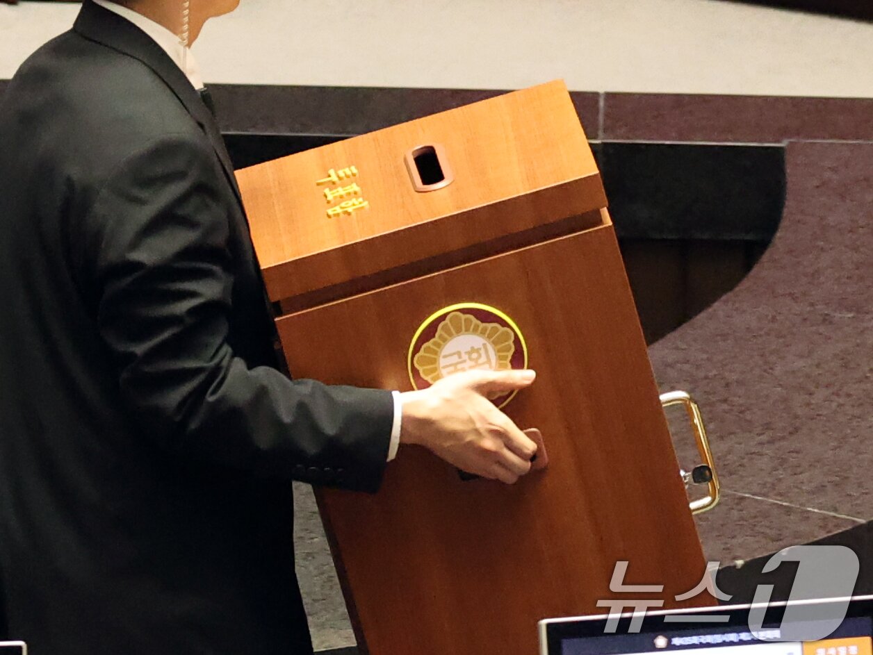 본문 이미지 - 7일 오후 서울 여의도 국회에서 열린 제435회 국회(임시회) 제1차 본회의에서 대한민국헌법 개정안이 국민의힘 의원 불참으로 투표가 불성립, 관계자가 투표함을 옮기고 있다. 2026.5.7 ⓒ 뉴스1 황기선 기자
