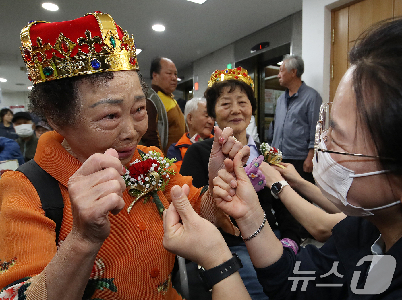 (부산=뉴스1) 윤일지 기자 = 어버이날인 8일 부산 부산진구노인복지관에서 어버이날 기념 행사가 열린 가운데 복지관 직원에게 카네이션을 받은 어르신이 눈물을 흘리며 손가락 하트를 …