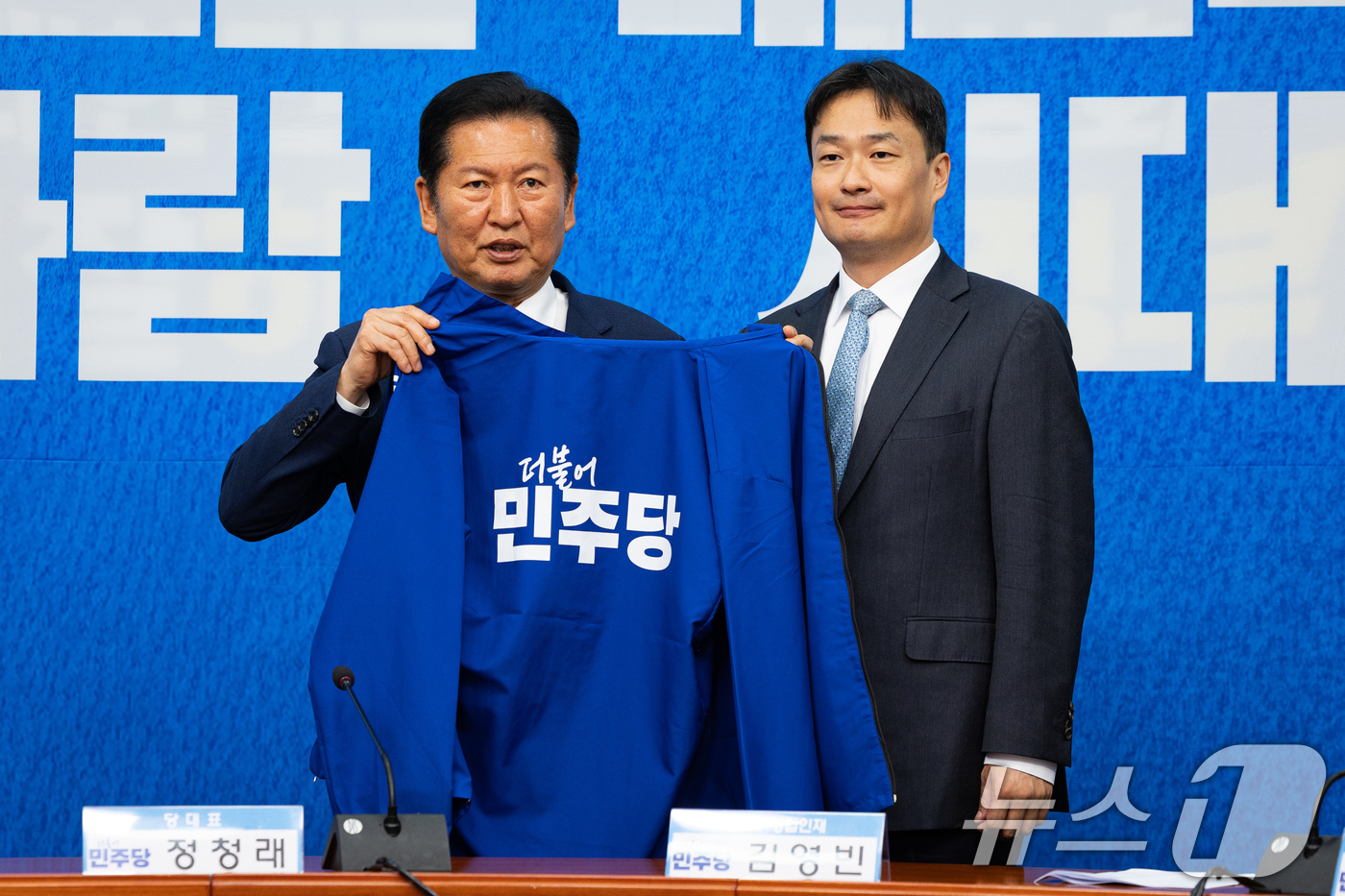 (서울=뉴스1) 유승관 기자 = 정청래 더불어민주당 대표가 8일 서울 여의도 국회에서 열린 제4차 인재영입식에서 김영빈 변호사에게 당 점퍼를 입혀주고 있다.김영빈 변호사는 6.3 …