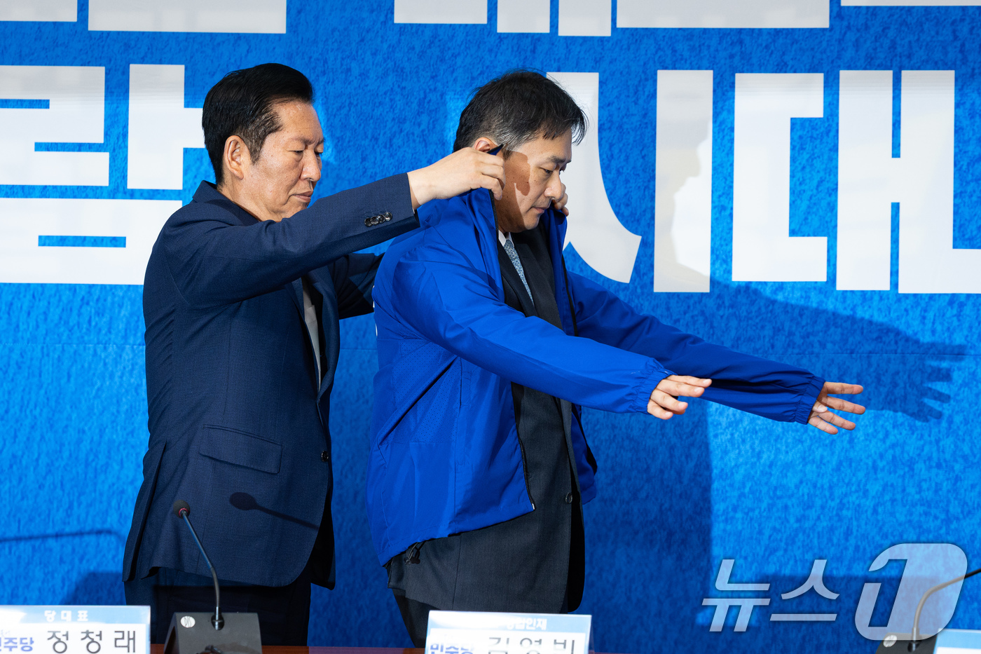 (서울=뉴스1) 유승관 기자 = 정청래 더불어민주당 대표가 8일 서울 여의도 국회에서 열린 제4차 인재영입식에서 김영빈 변호사에게 당 점퍼를 입혀주고 있다.김영빈 변호사는 6.3 …